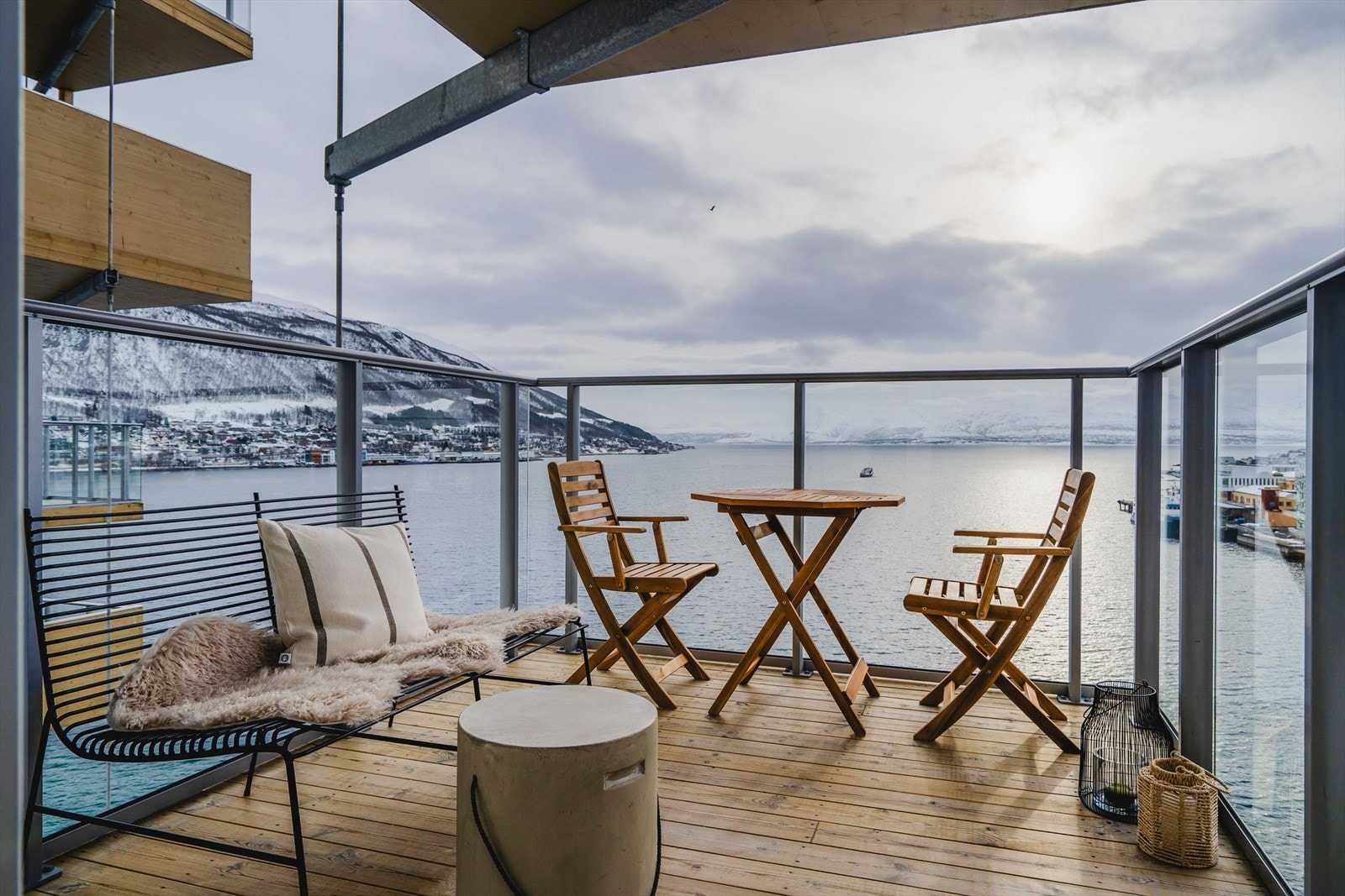 Adkomst fra stue til sørvendt og solrik balkong med nydelig utsikt over sundet, fastlandet, sør-Tromsøya, Kvaløya og Malangen. Galleribilde