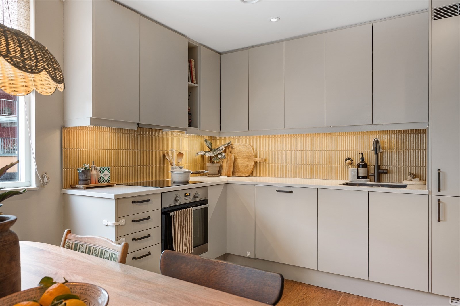 Kjøkken med moderne innredning med glatte fronter og slitesterk kompositt benkeplate. Integrert kjøl/fryseskap, oppvaskmaskin, komfyr og platetopp. Galleribilde