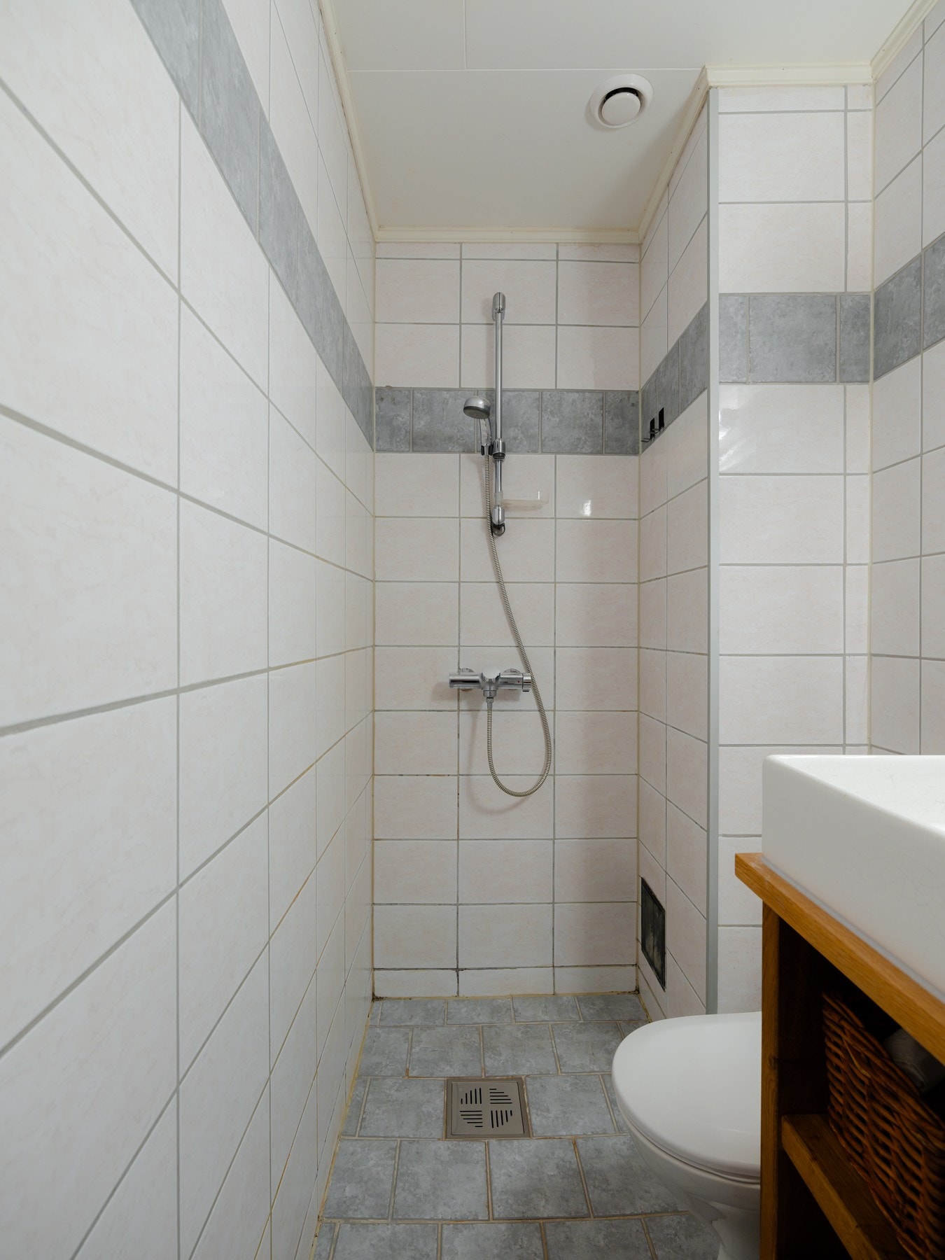 Innredningen består gulvstående toalett og dusjhjørne. Galleribilde