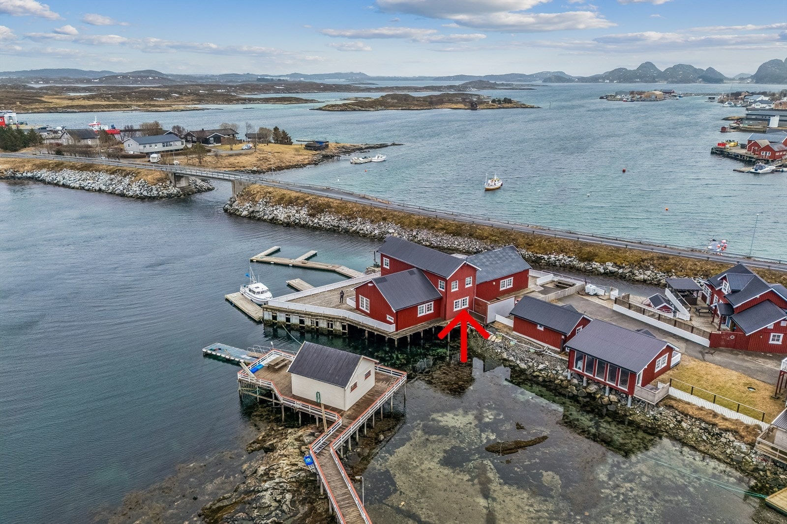 Eiendommen ligger ved vannkanten med praktisk bryggeanlegg. Til høyre bak i bildet ser vi Øksningan i Herøy. Galleribilde