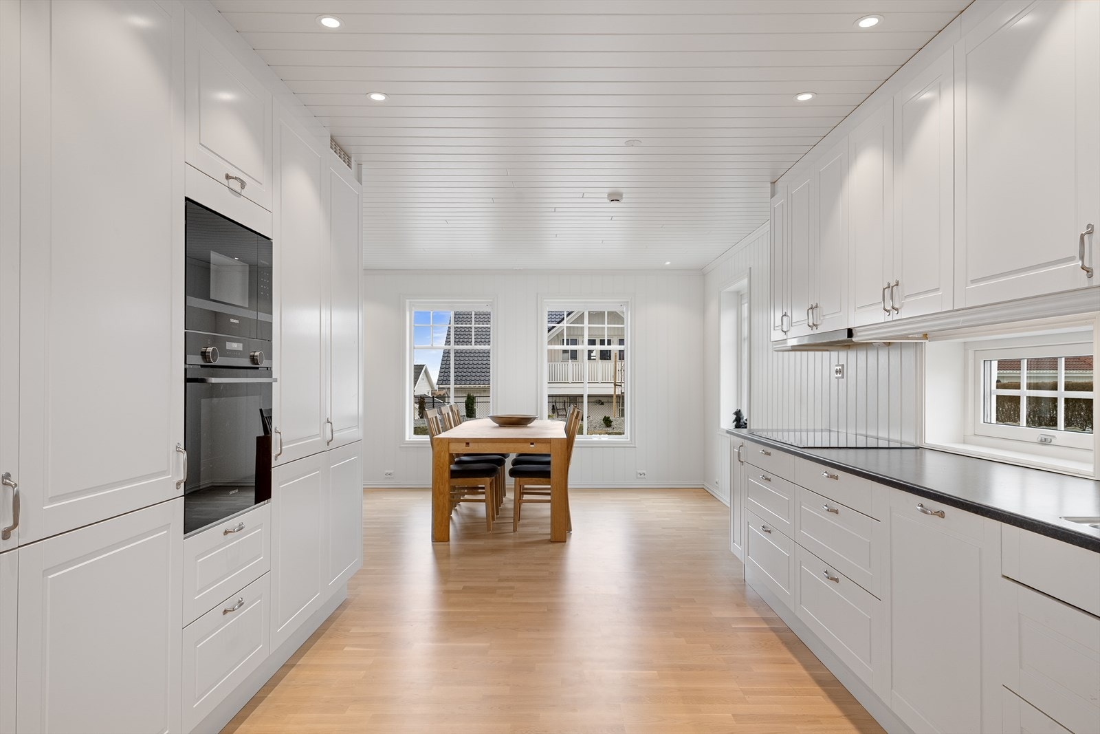 Kjøkkenet har profilerte fronter og benkeplate av laminat med planlimt vask. Integrerte hvitevarer. Galleribilde