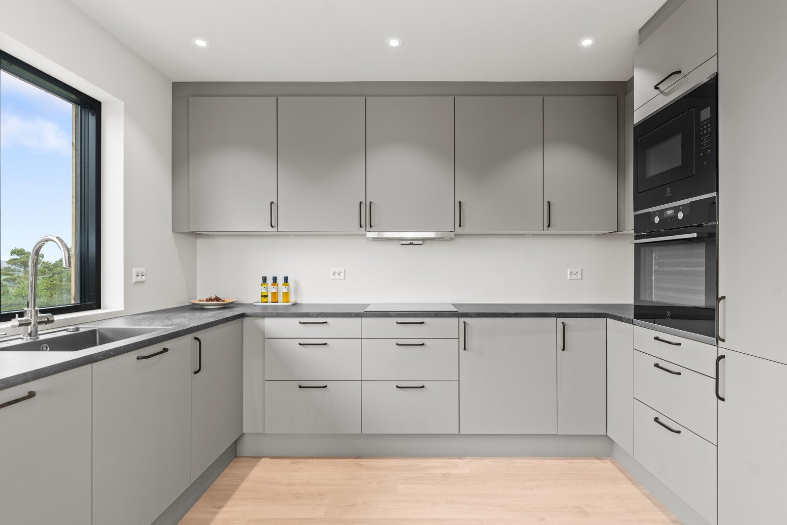 Kjøkkenet har integrerte hvitevarer i sorte detaljer. Galleribilde