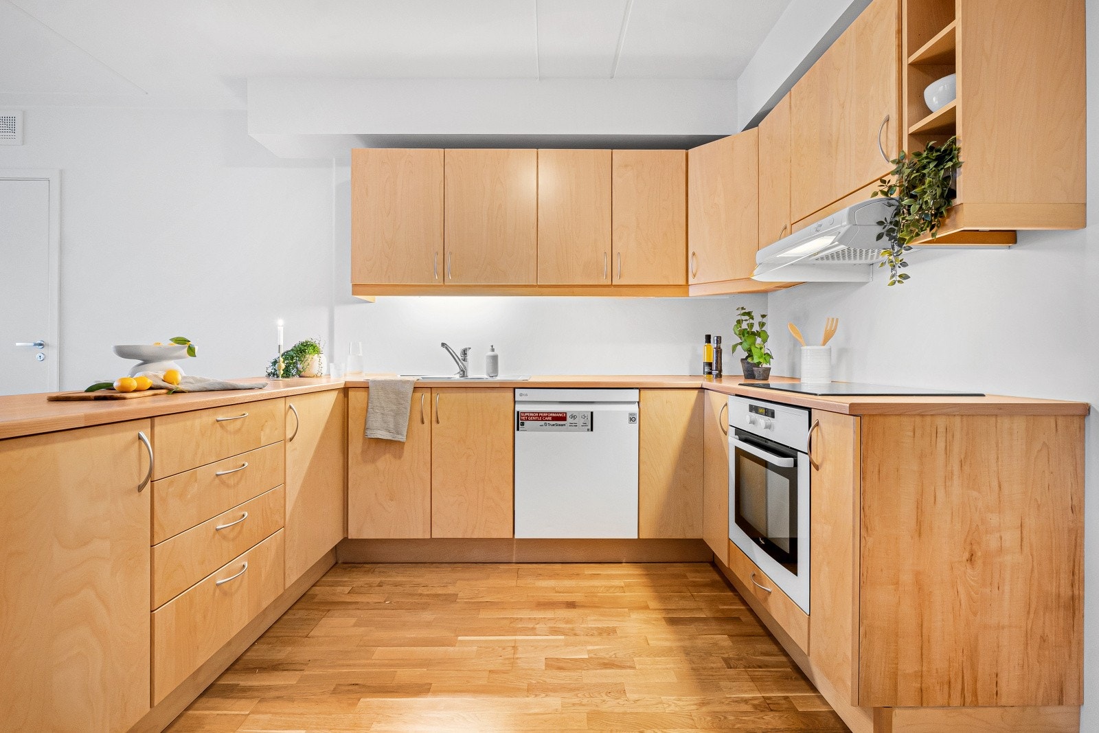 Den U-formede kjøkkenløsningen gir rikelig med både skap- og benkeplass Galleribilde