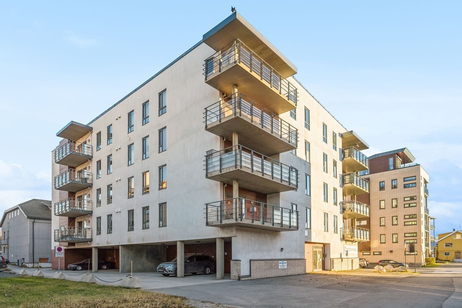 Utvendig gjesteparkering i carport på nordsiden av bygget. Galleribilde