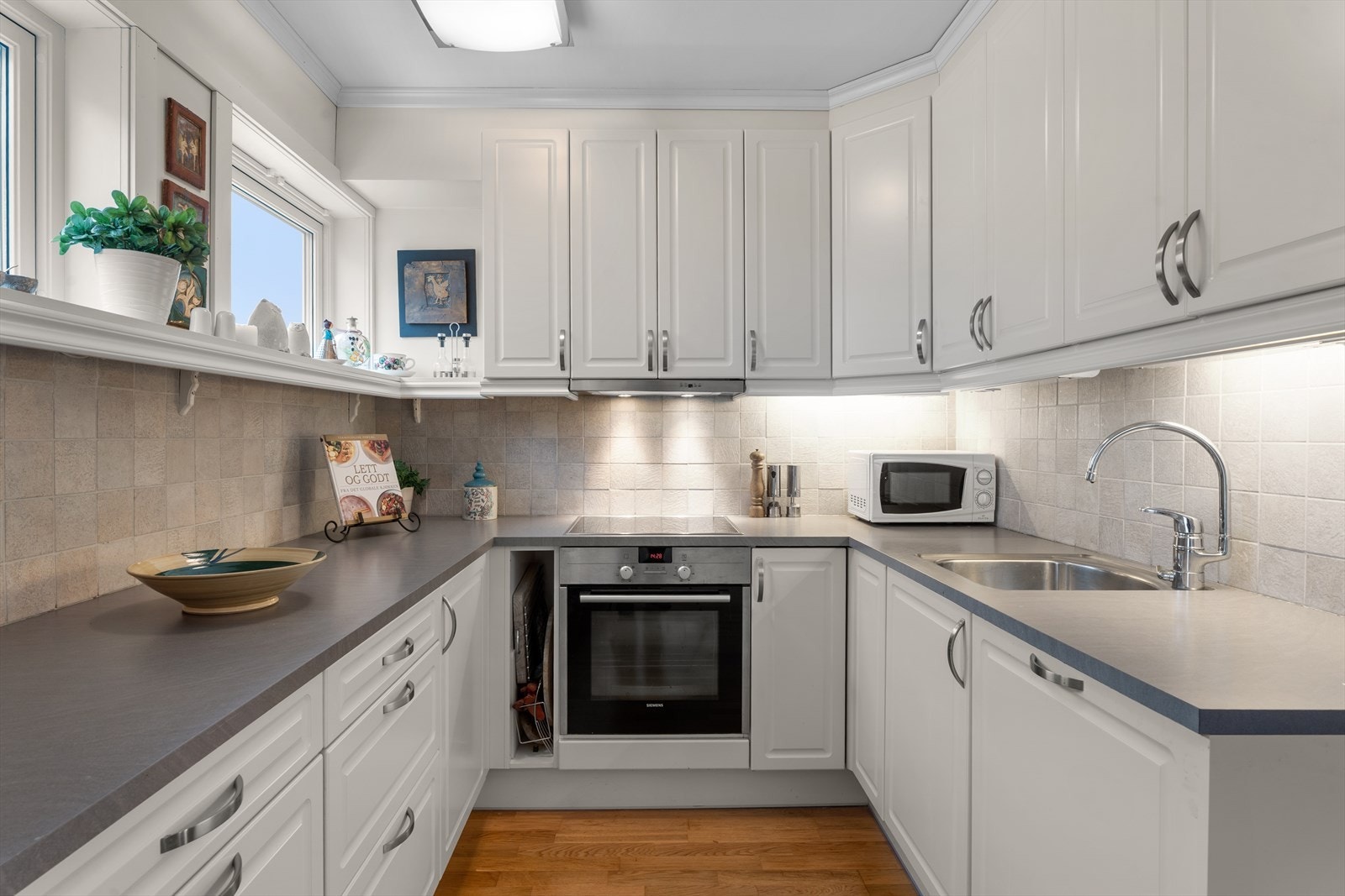 HTH kjøkkeninnredning med profilerte fronter og integrerte hvitevarer gir en praktisk arbeidsplass. Galleribilde