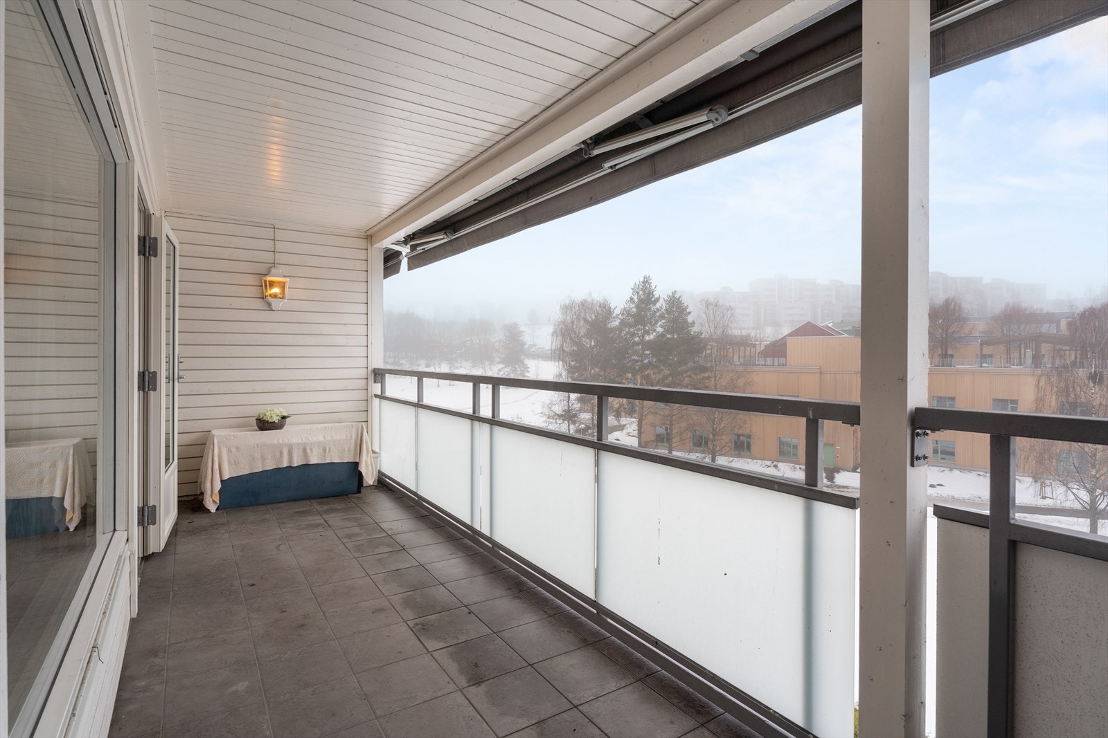 Flislagt gulv og vegghengt utelampe gir en praktisk og innbydende balkong. Galleribilde