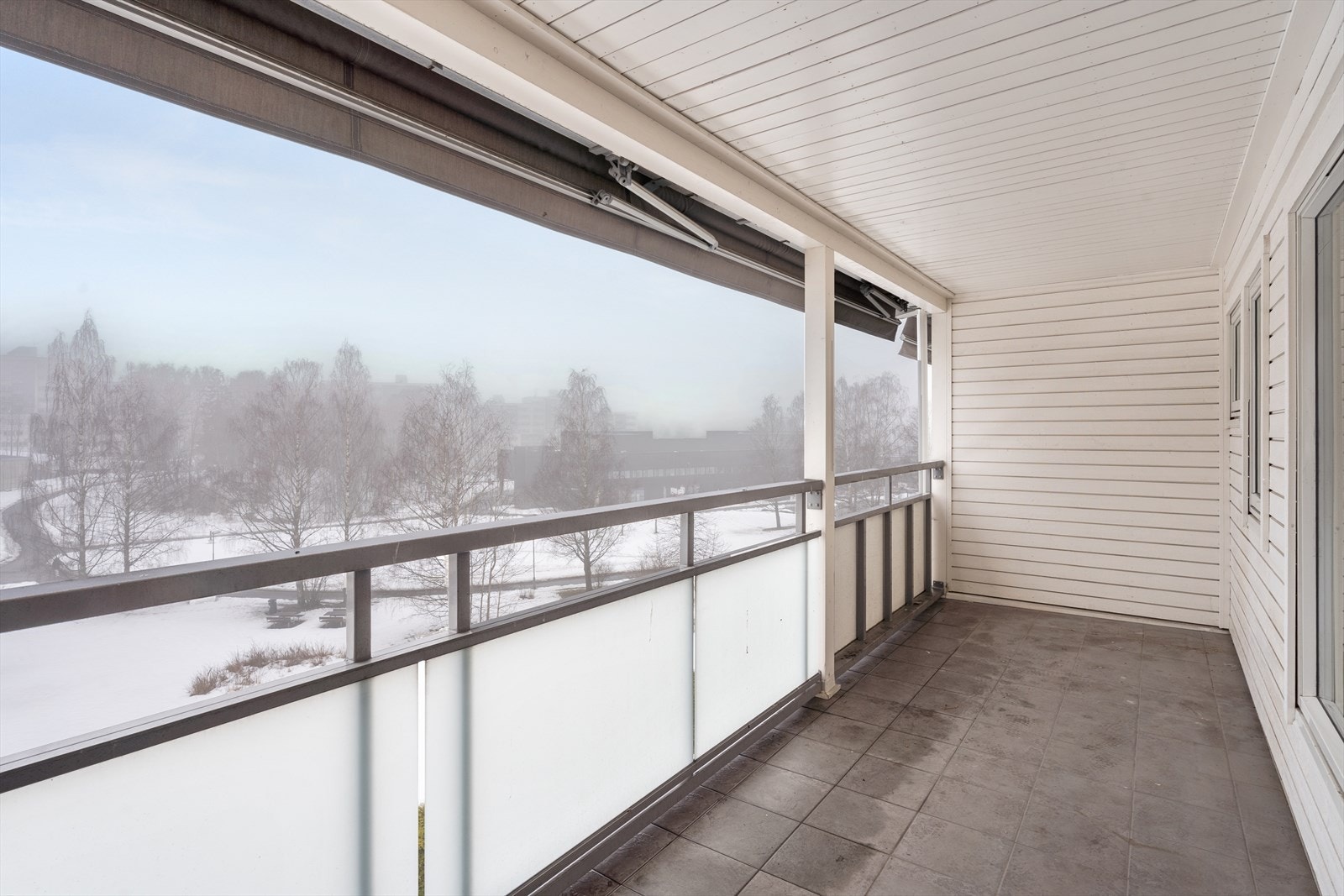 Store vindusflater gir utsyn mot grøntområde og skaper en lys atmosfære. Galleribilde