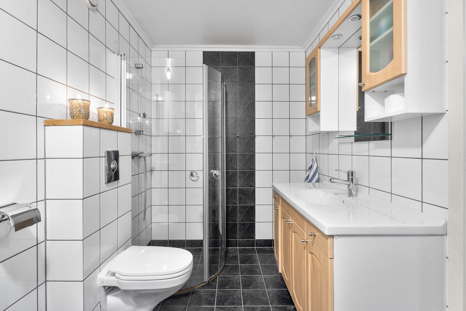 Badet er utstyrt med veggmontert toalett og dusjhjørne. Galleribilde