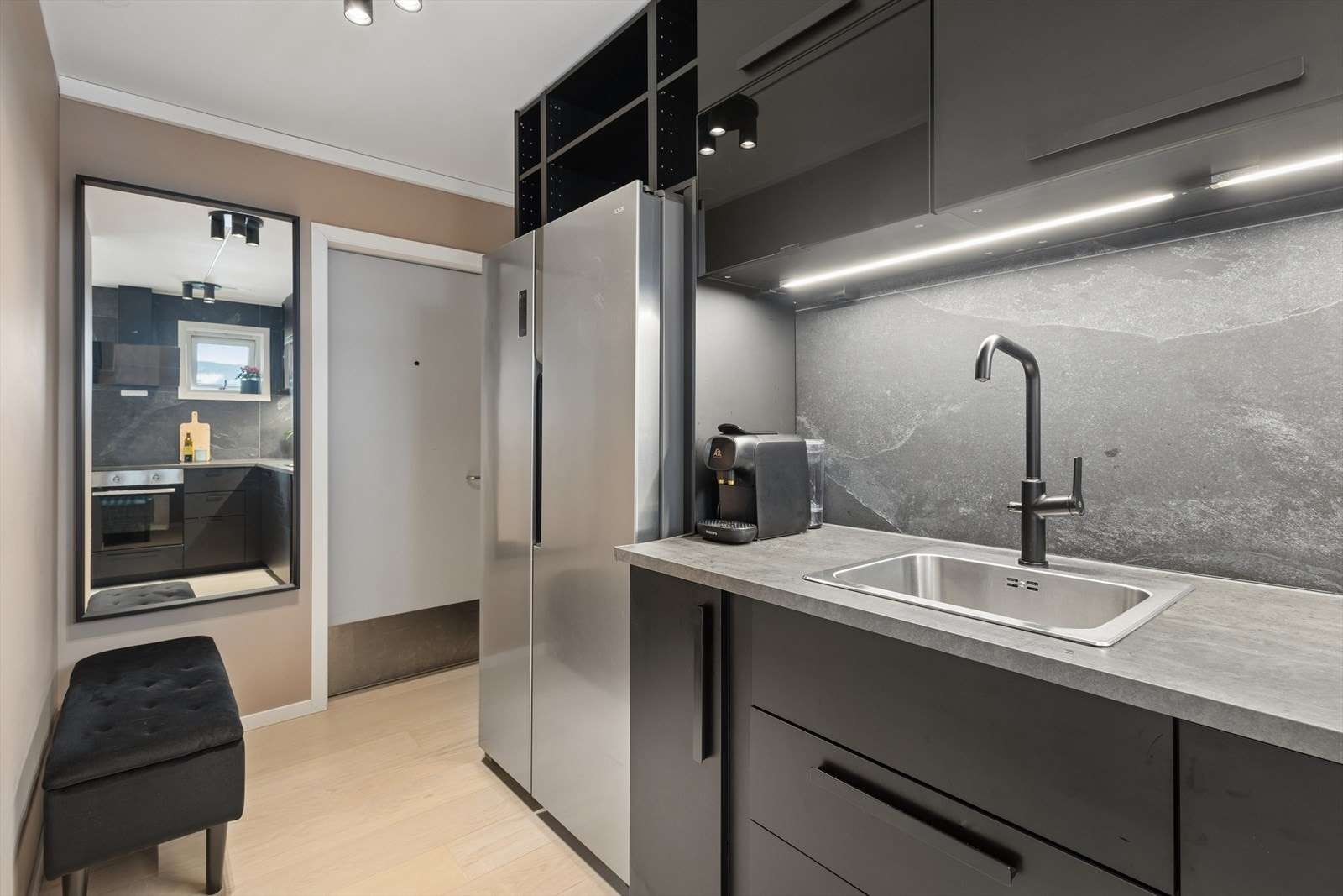 Kjøkkeninnredningen har glatte, mørke fronter og en slitesterk laminert benkeplate. Galleribilde