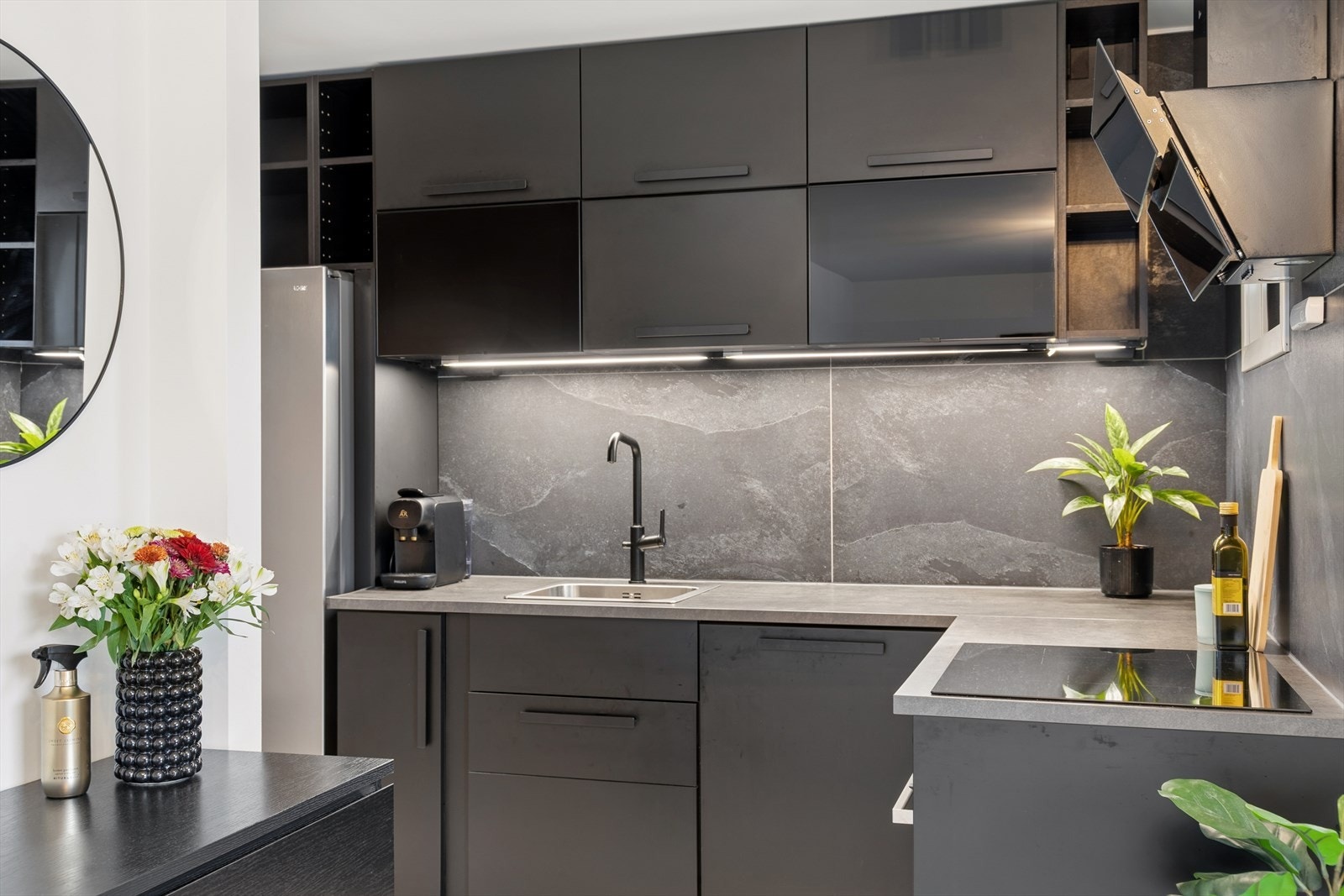 Leiligheten har en åpen løsning mellom stue og et moderne kjøkken med integrerte hvitevarer. Galleribilde