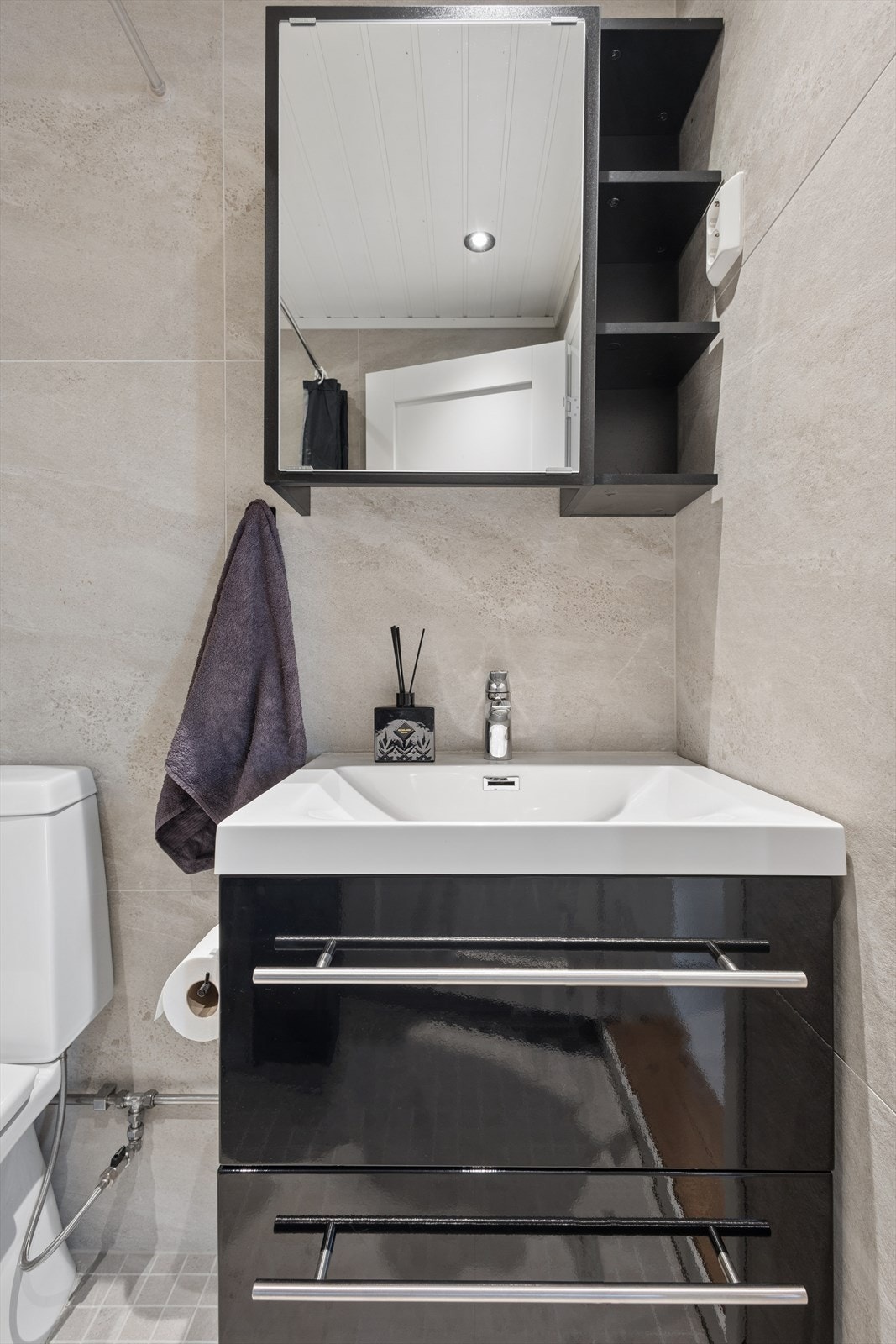 Badet er innredet med servant med underskap og et praktisk speilskap med oppbevaring. Galleribilde