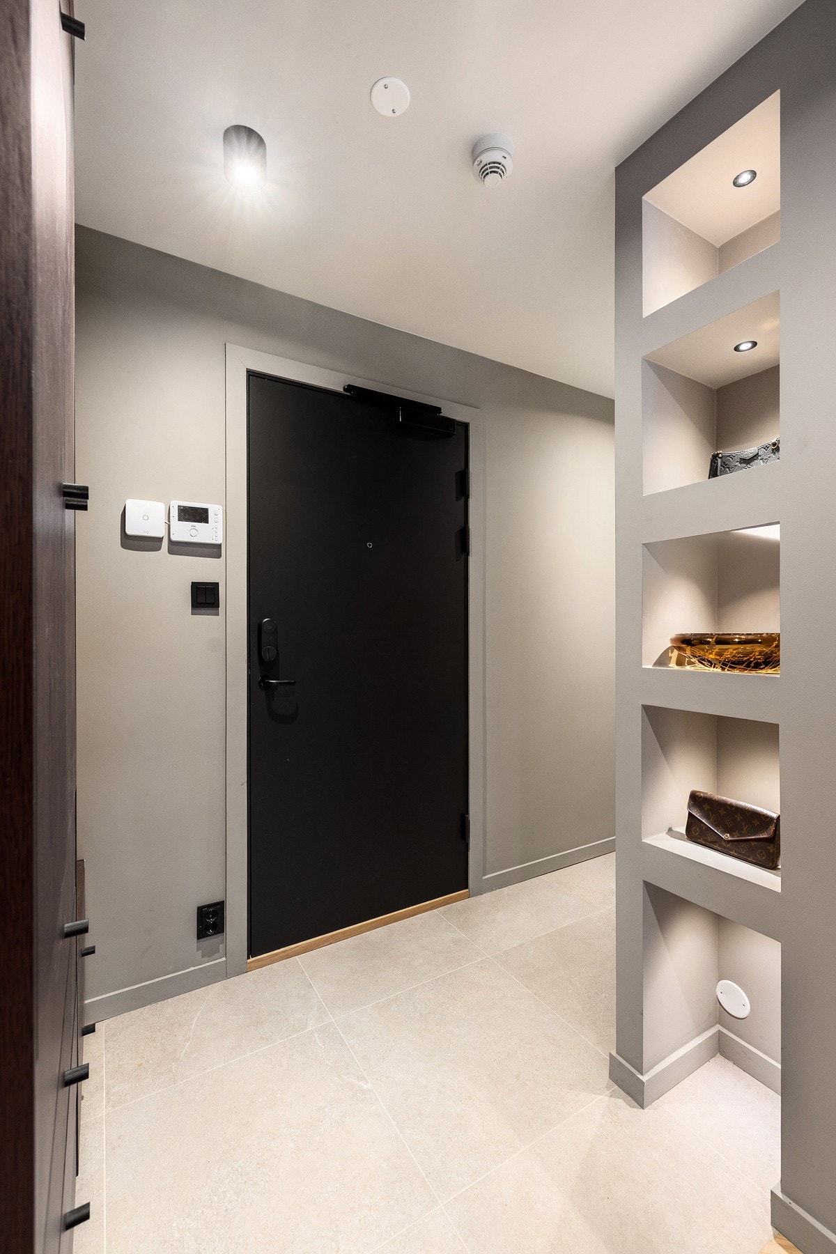 Smart flislagt gulv i første del av entréen samt en fin og belyst nisje med plass til vesker etc. Galleribilde