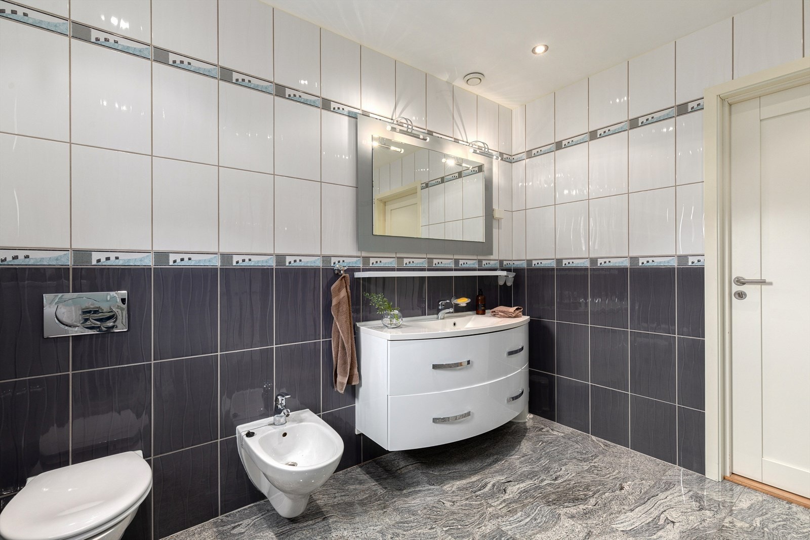 Badet er utstyrt med servant med innredning, spegel, toalett, bidé og dusjkabinett. Galleribilde