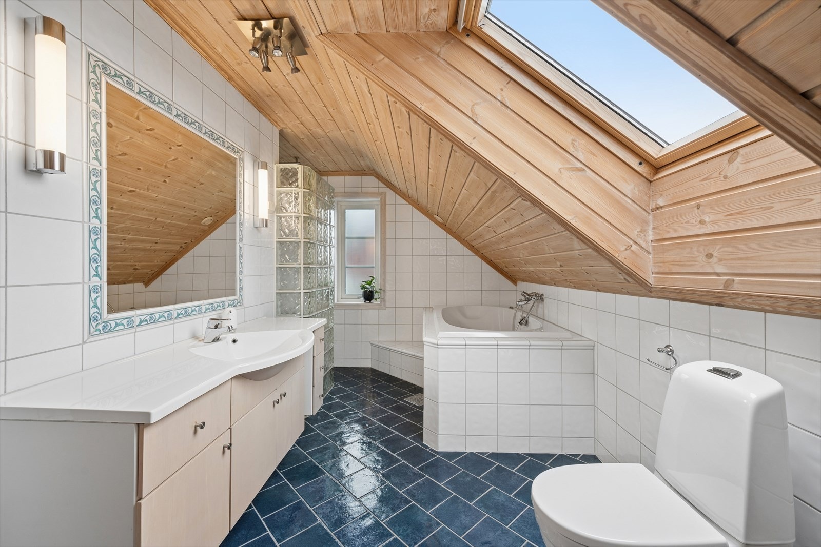 Enkel og praktisk innredning med servant med underskap og innfliset speil. Galleribilde