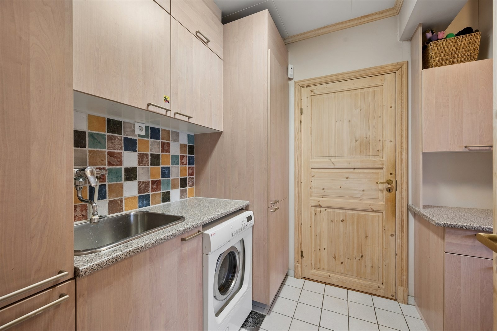 Veg i vegg med toalettrommet ligger det praktiske vaskerommet, med god skapplass, utslagsvask og opplegg for vaskemaskin. Galleribilde