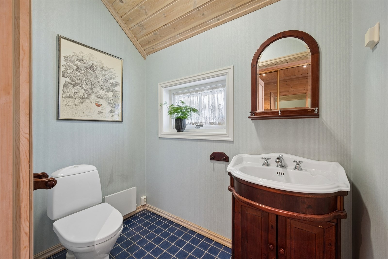 I tilknytning entreen ligger boligens toalettrom. Praktisk og enkelt innredet med gulvfestet toalett og servant. Galleribilde