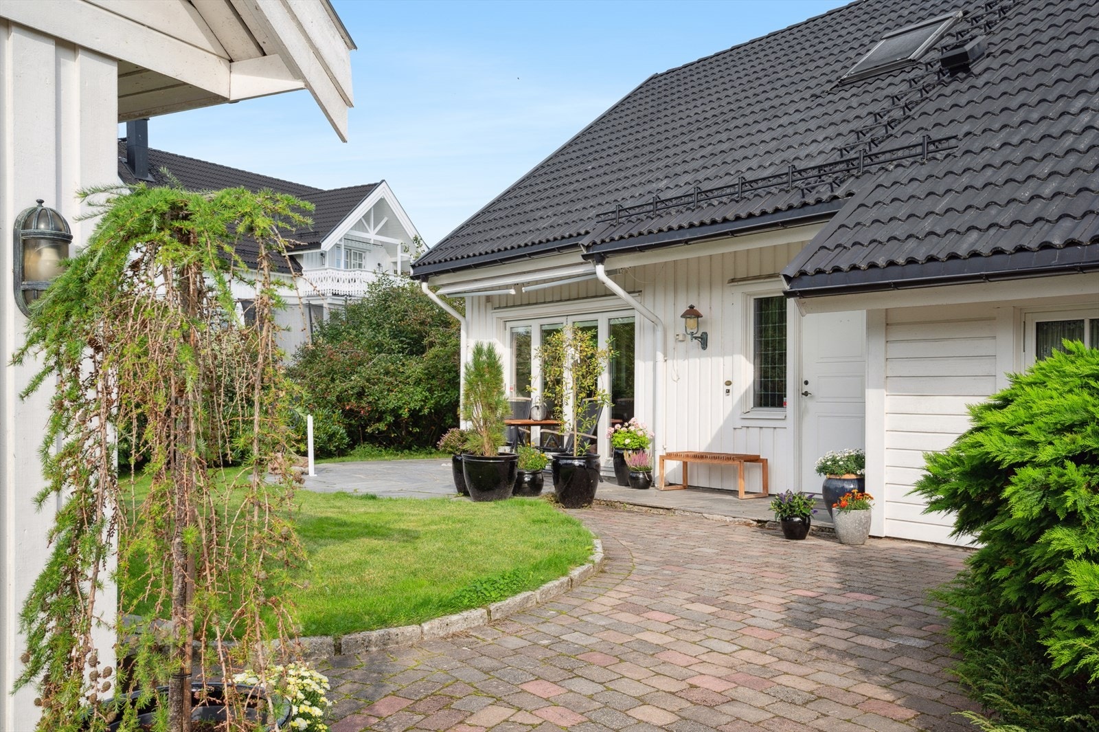 Innbydende adkomst med belegningsstein og hyggelig beplantning. Galleribilde