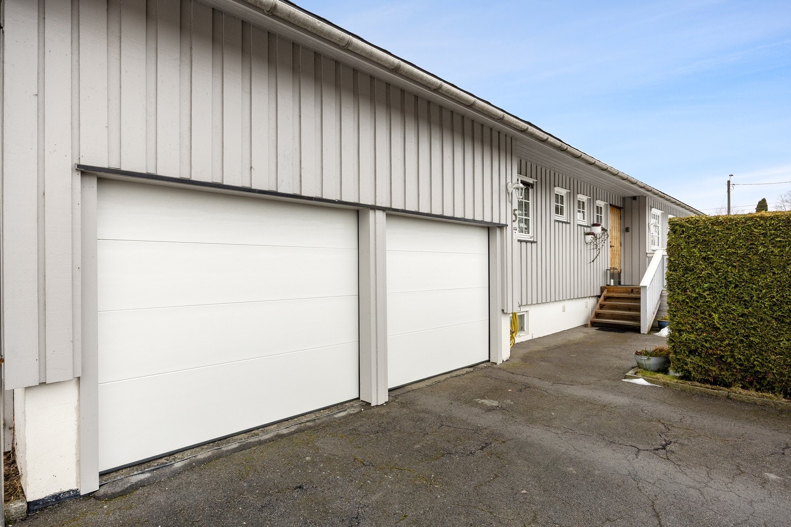Eneboligen har en integrert dobbelgarasje med trapp ned til kjelleren - så her går man tørrskodd inn i all slags vær. Det er elektriske portåpnere Galleribilde