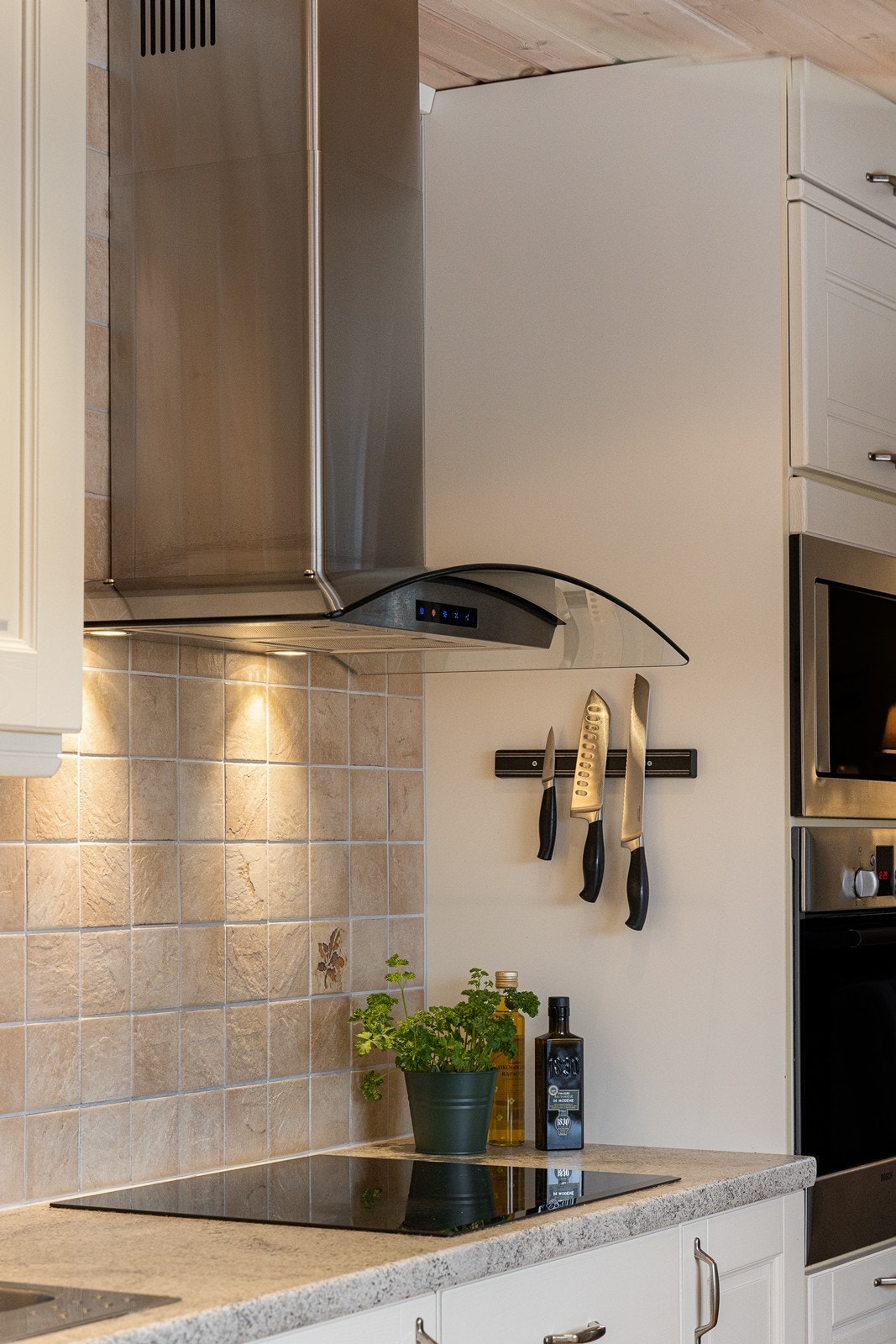 Integrert i innredningen finner man stekeovn, induksjonstopp, oppvaskmaskin og mikrobølgeovn. Ovnene er praktisk plassert i et høyskap. Galleribilde