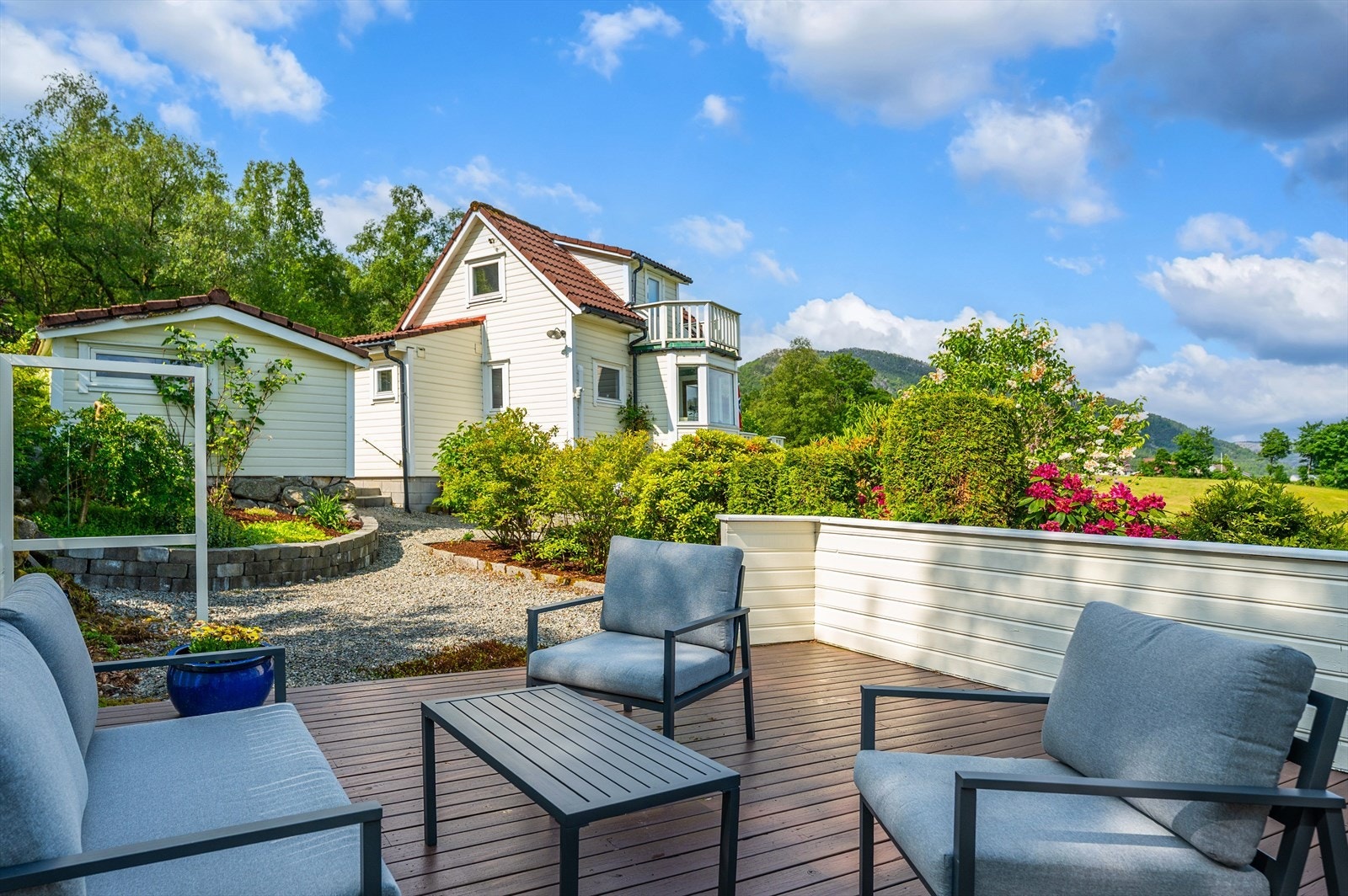 Uteområdet byr på terrasser, plen, bed og beplantning som skaper en idyllisk ramme. Galleribilde