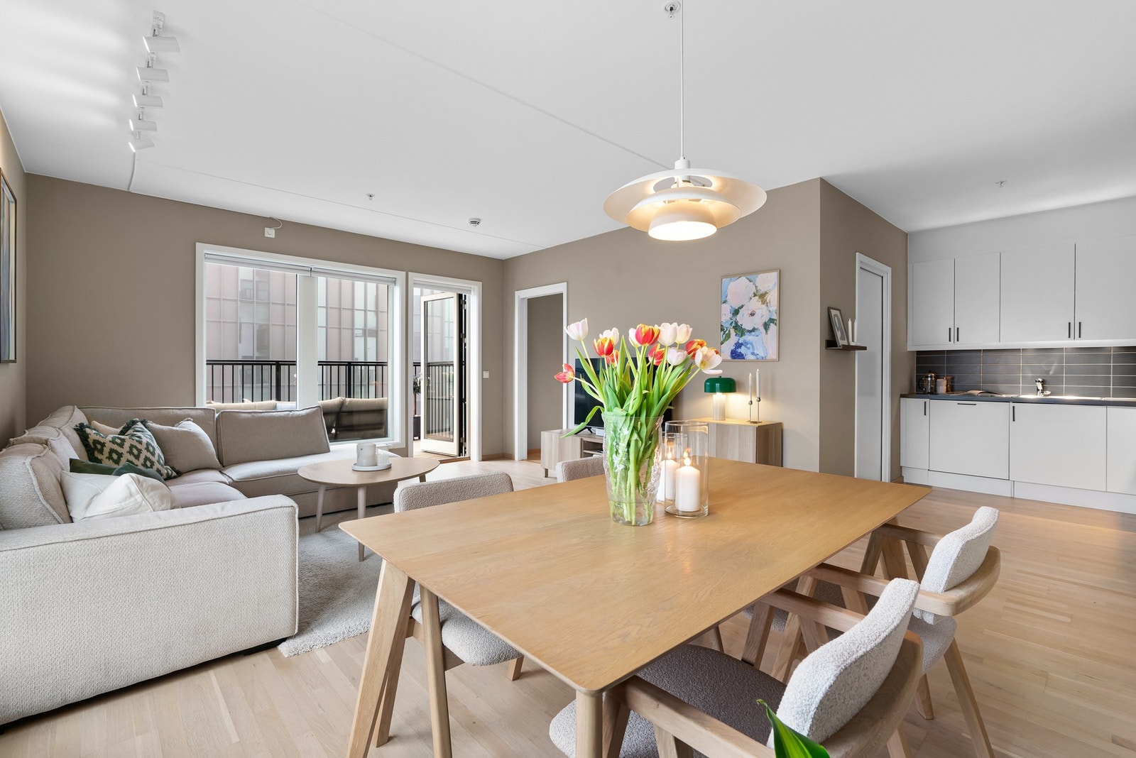 I tilknytning til stuen finner vi en moderne, åpen kjøkkenløsning med lys innredning. Galleribilde