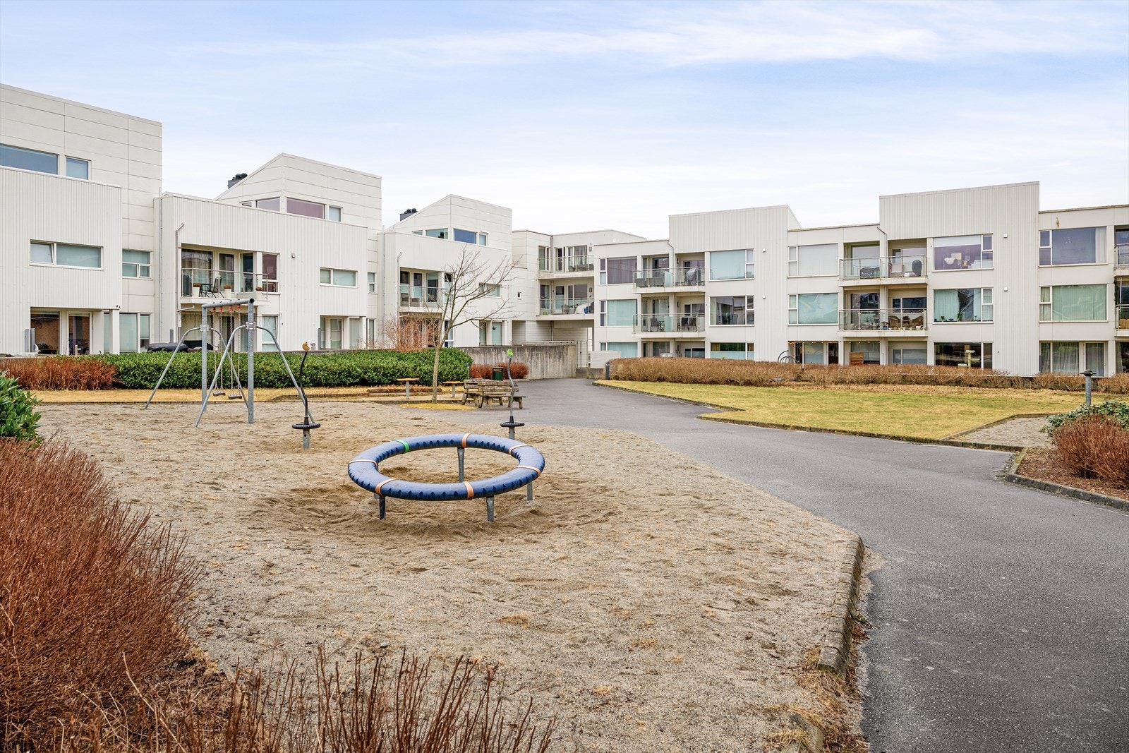 Det er pent grøntareal like utenfor leiligheten med lekeplass, sittegrupper og gressplen. Galleribilde
