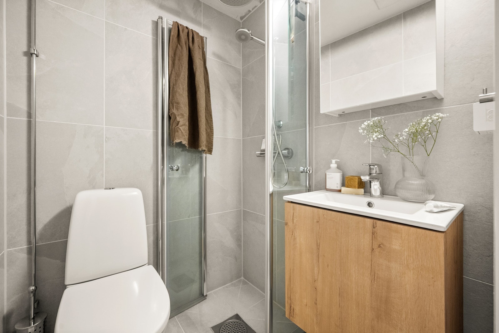 Innredet med klosett, baderomsinnredning med servant og speilskap med lys. Galleribilde