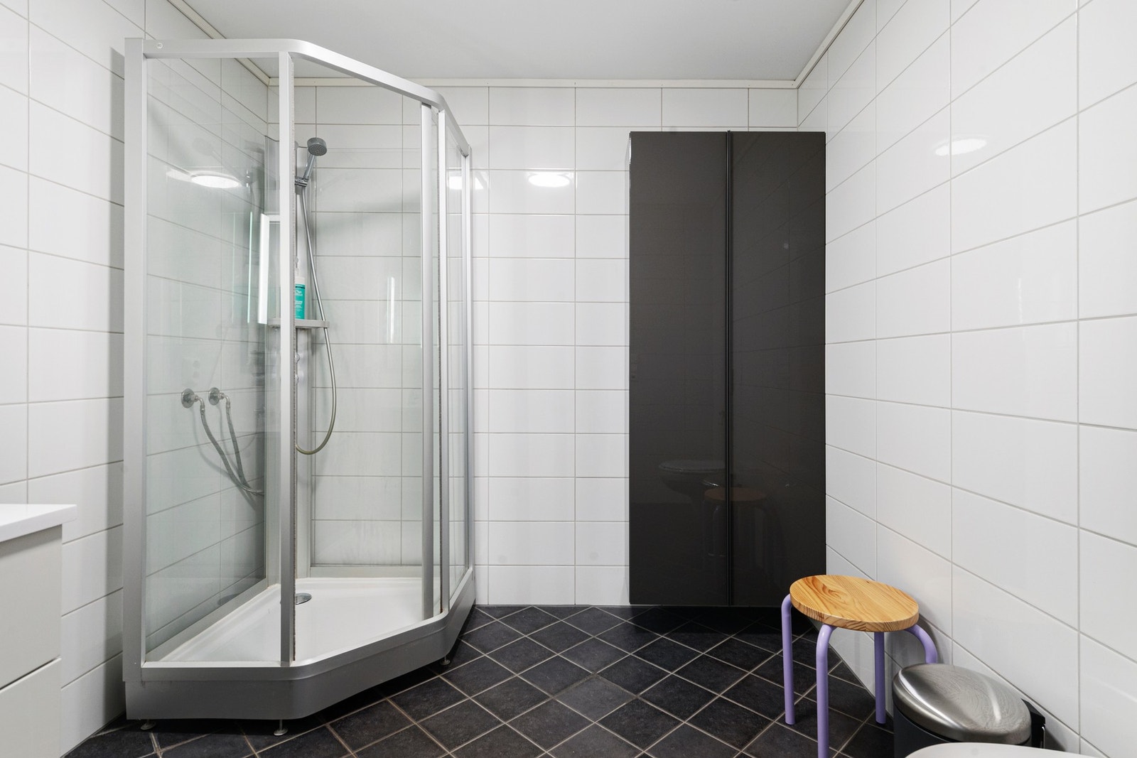 Badet er innredet med baderomsinnredning med heldekkende servant, vegghengt toalett og dusjkabinett Galleribilde