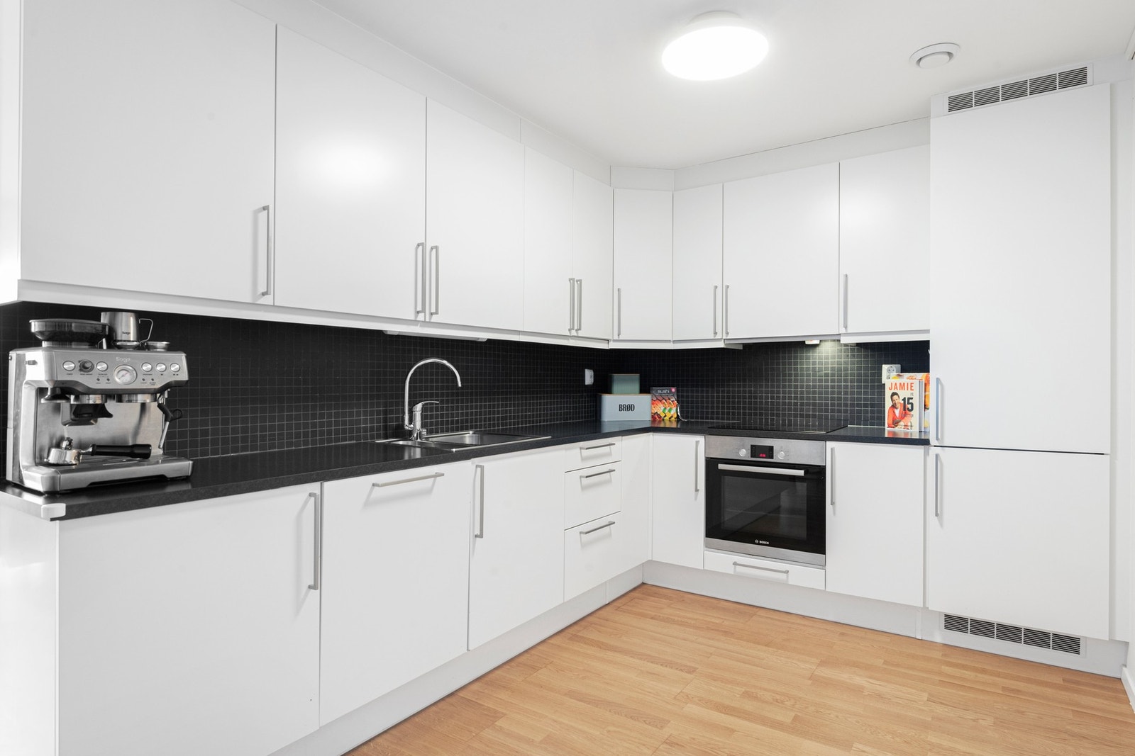 Kjøkkeninnredning fra HTH med integrerte hvitevarer som stekeovn, induksjonstopp, oppvaskmaskin og kombinert kjøl-/fryseskap Galleribilde