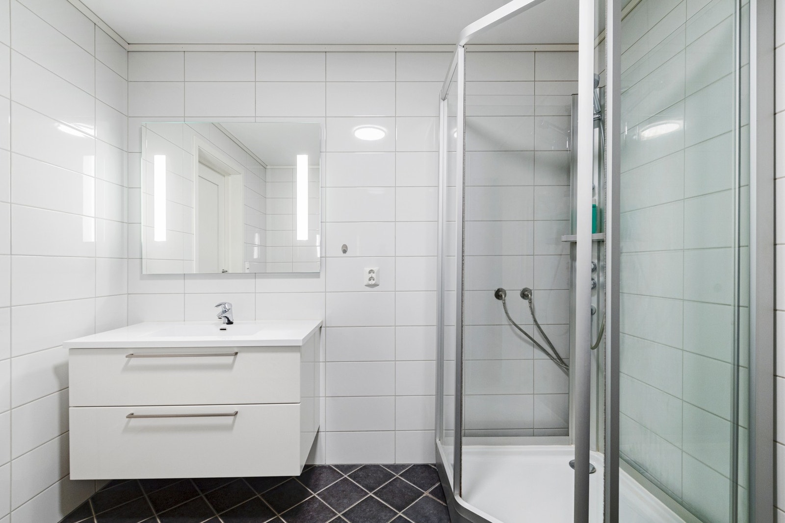 Bad i 2. etasje har flislagt gulv med gulvvarme, flislagte vegger og malt slett himmling Galleribilde