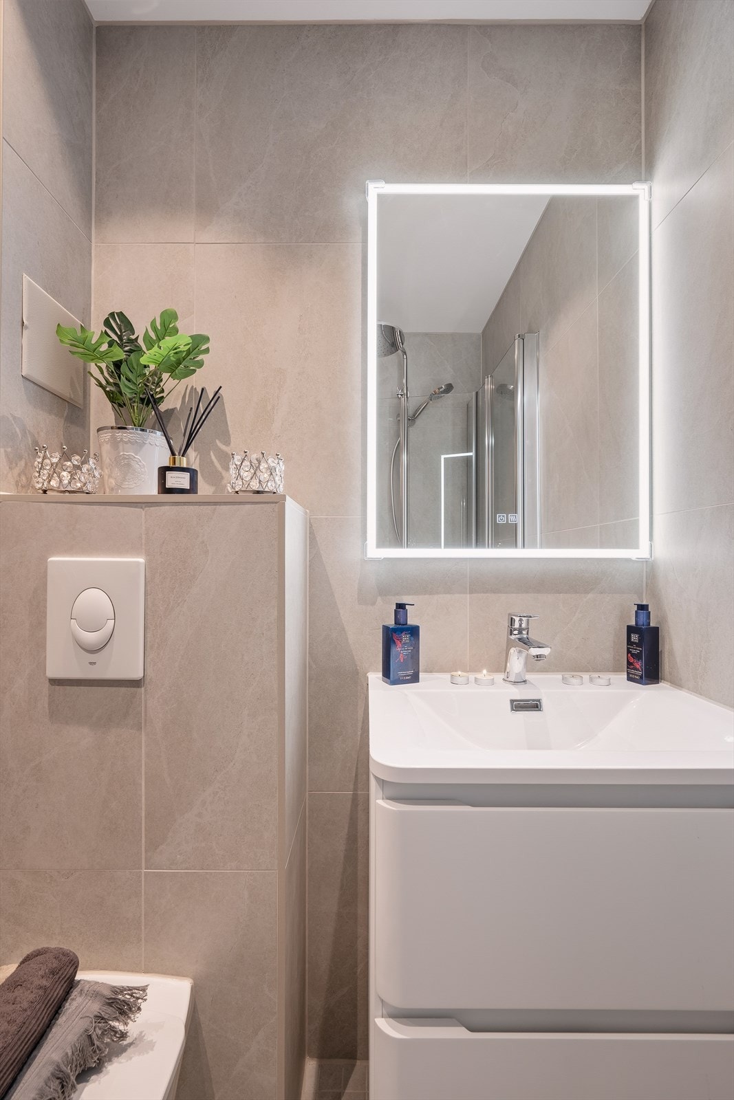 Rommet er innredet med vegghengt toalett, servant med skap og et praktisk dusjhjørne. Galleribilde