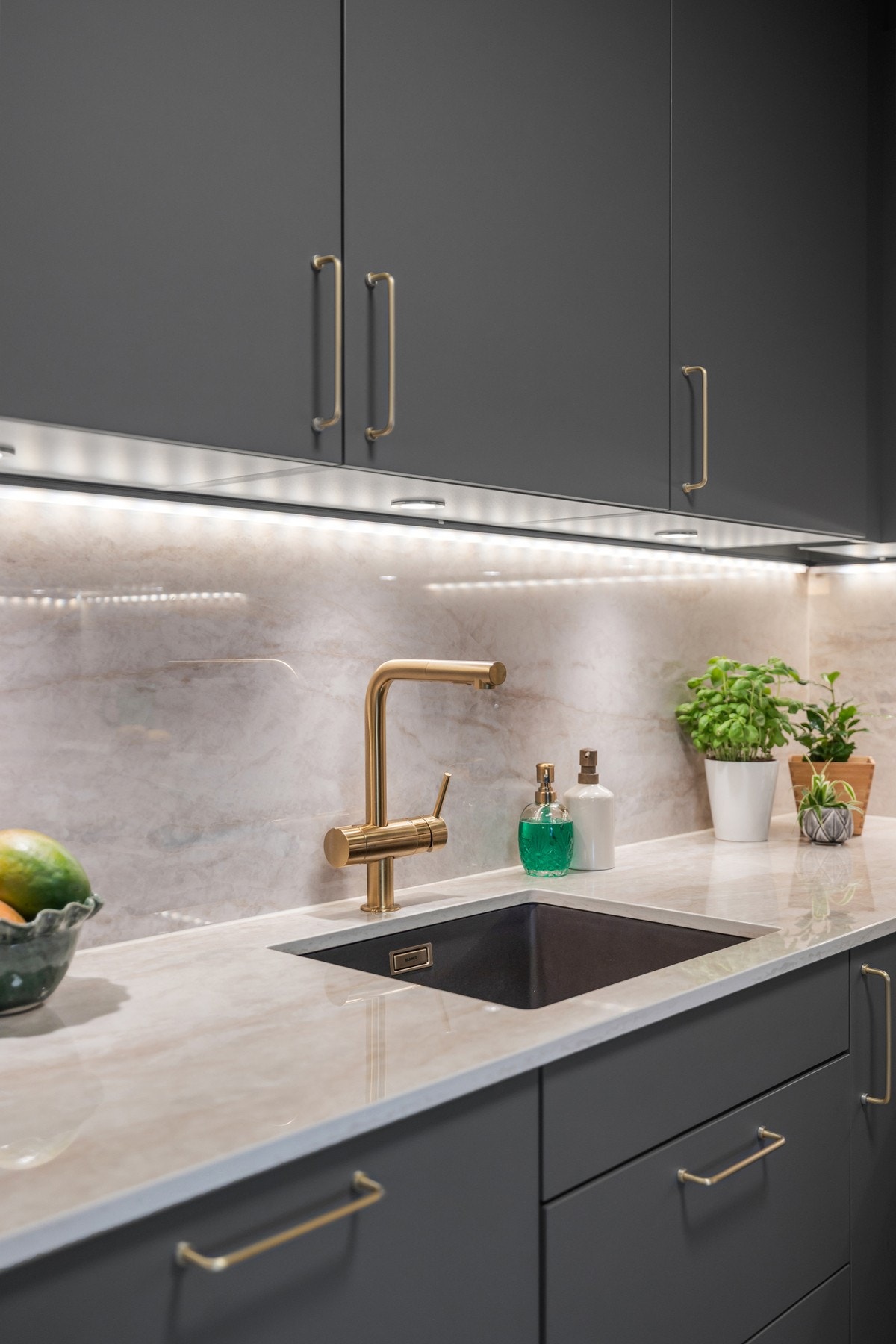 Benkeplate av typen Dekton Arga, ultrakompakt keramisk benkeplate. Integrert underlimt vask.Veggplate i samme materiale over benkeplate. Galleribilde