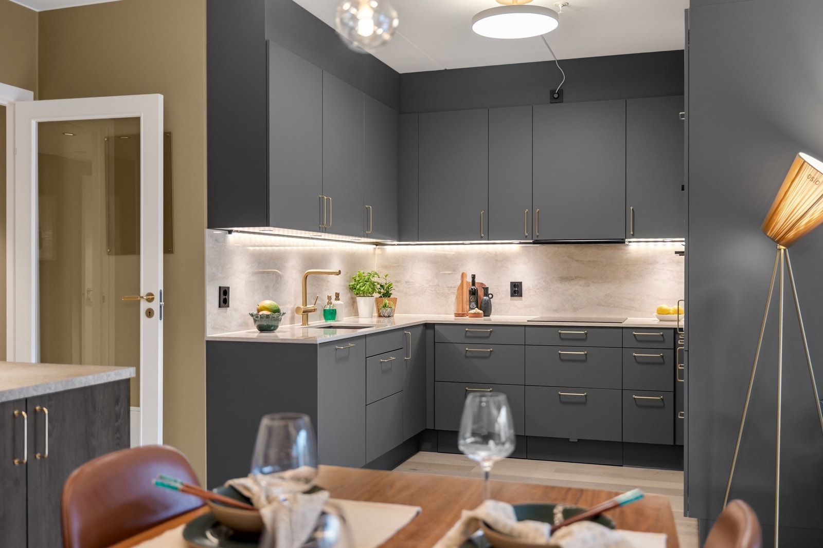 Kjøkkenet har stilrene glatte fronter, gode arbeidsflater og god oppbevaringsplass - Et funksjonelt og innbydende rom for både matlaging og sosialt samvær. Galleribilde