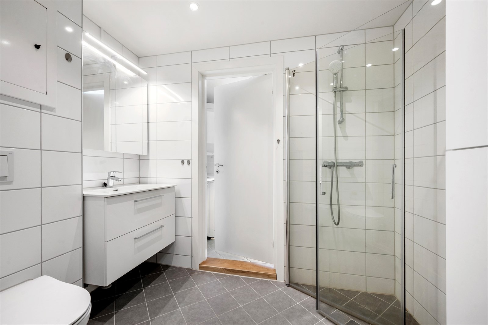 Bad, vaskerom og toalett ble totalrenovert i 2021. Badet er innredet med dusjnisje, vegghengt toalett og servant med underskap. Galleribilde