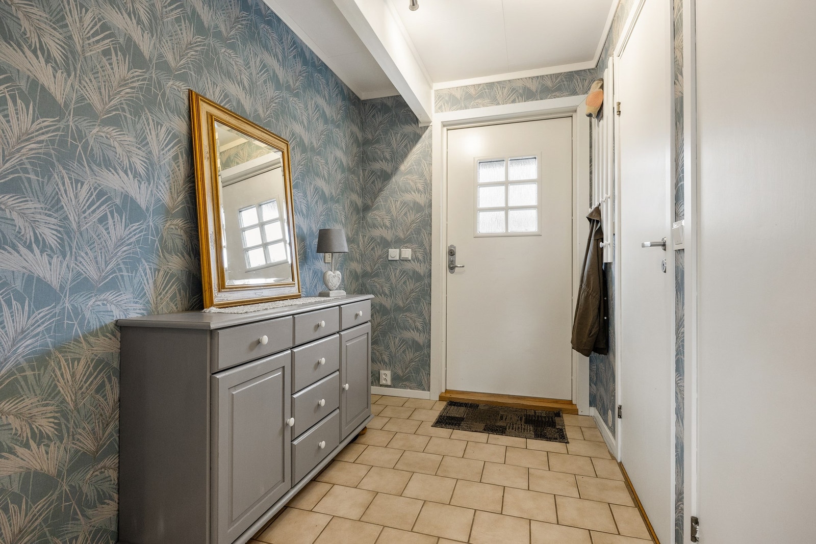 Velkommen inn. Entréen har praktiske fliser på gulvet og god plass til oppbevaring. Galleribilde