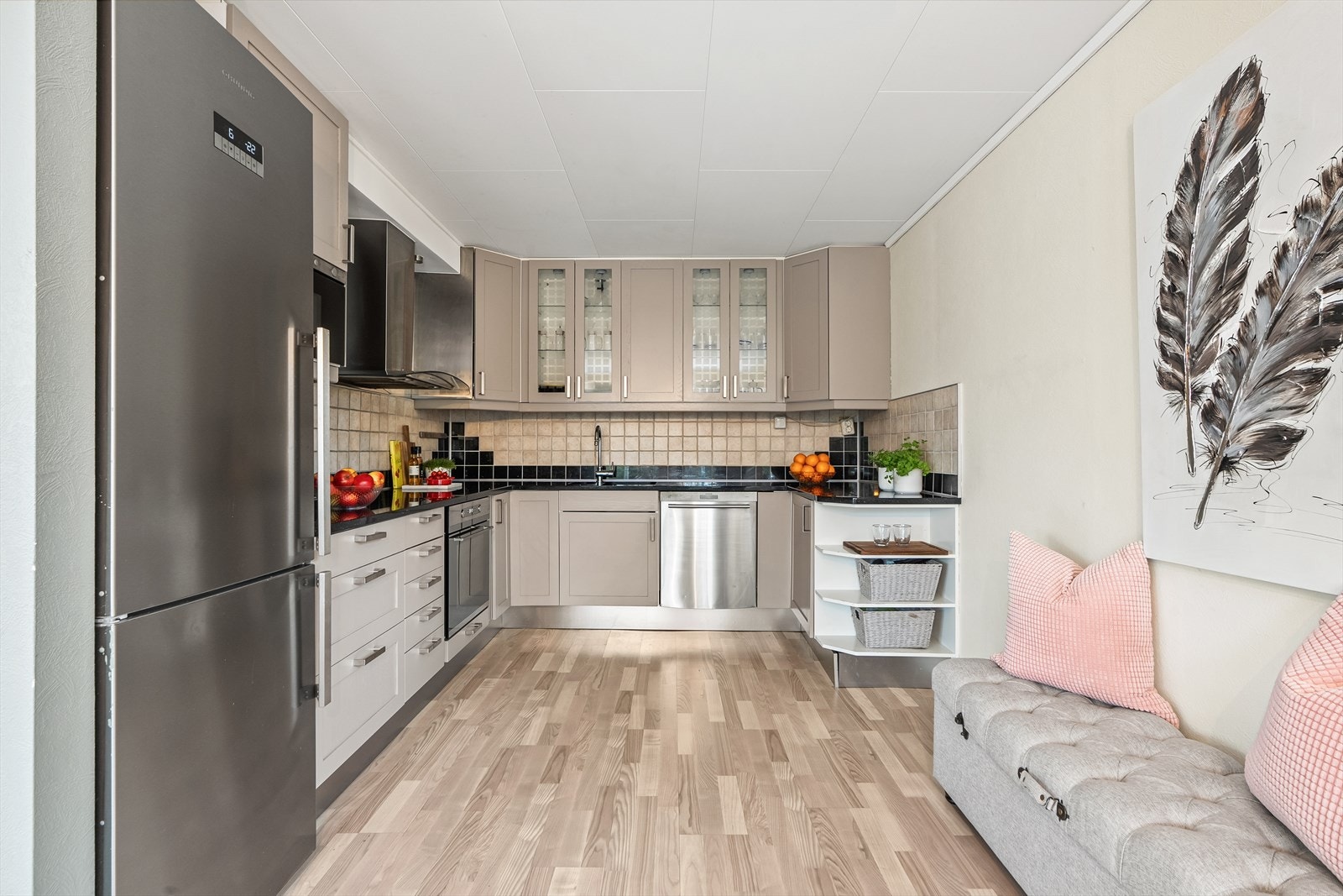 Eldre kjøkkeninnredning med nymalte fronter (2026) og noen vitrinedører som overskap. Galleribilde