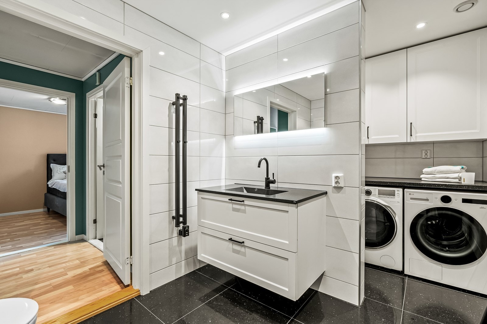 Videre er det opplegg for vaskemaskin og tørketrommel under laminat benkeplate. Galleribilde