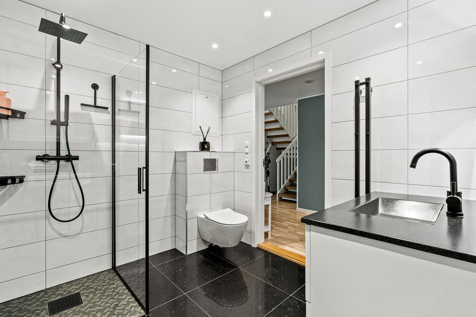 Det er baderominnredning med profilerte folierte fronter, heldekkende servant i kompositt, speil med lysarmatur, veggmontert toalett, utslagsvask montert på vegg, dusjhjørne med svingdører, regnfallsdusj, sluk i sone og dusjutstyr. Galleribilde