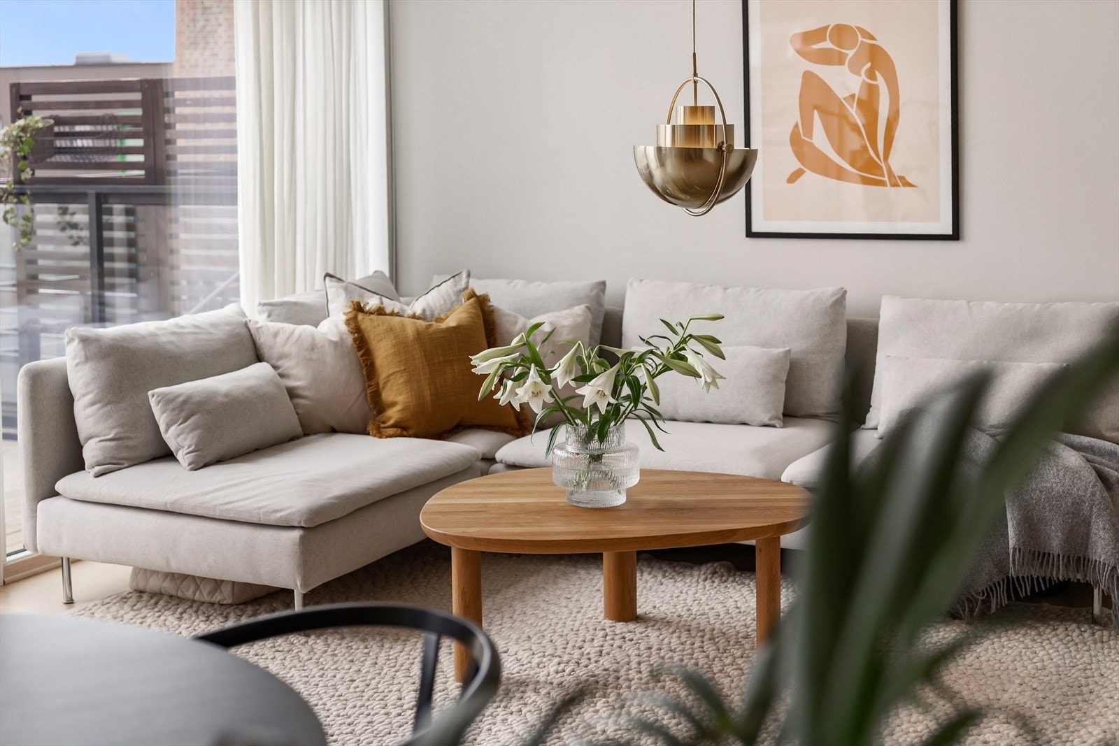 Innbydende og lys stue med fleksibel møblering, utgang til solrik 14 m² balkong og hyggelig utsikt over byen og fellesarealer. Galleribilde