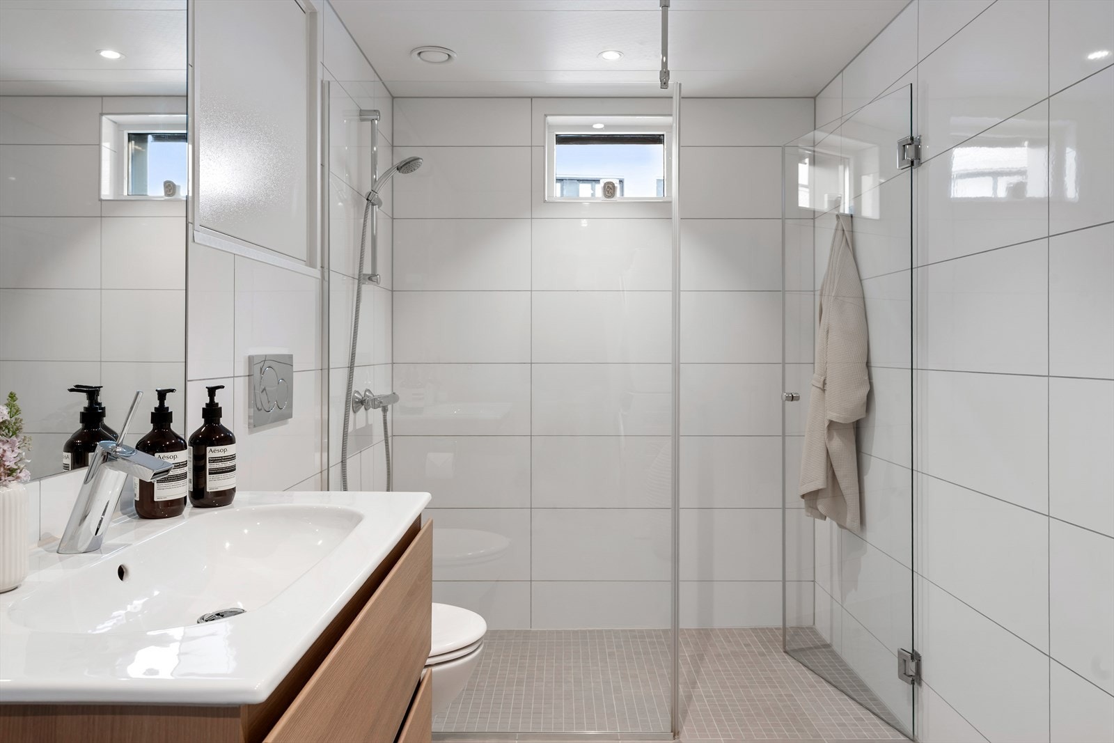 Badet fremstår som lyst og tiltalende, med flislagte overflater som gir et tidløst og stilrent uttrykk. Galleribilde