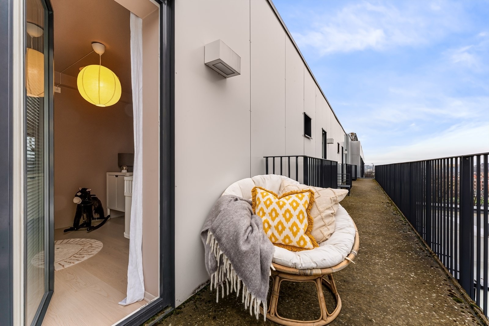 Fra soverom ll er det utgang til svalgang/brannbalkong med hyggelig kveldssol og utsikt over byens tak. Galleribilde