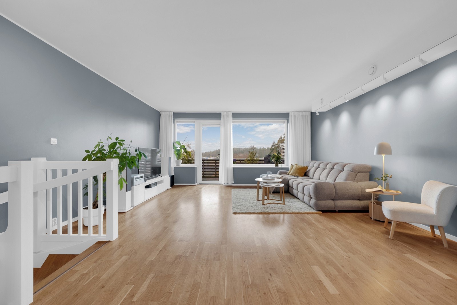 Stuen har store vindusflater som slipper inn rikelig med naturlig lys og gir rommet en luftig atmosfære. Galleribilde