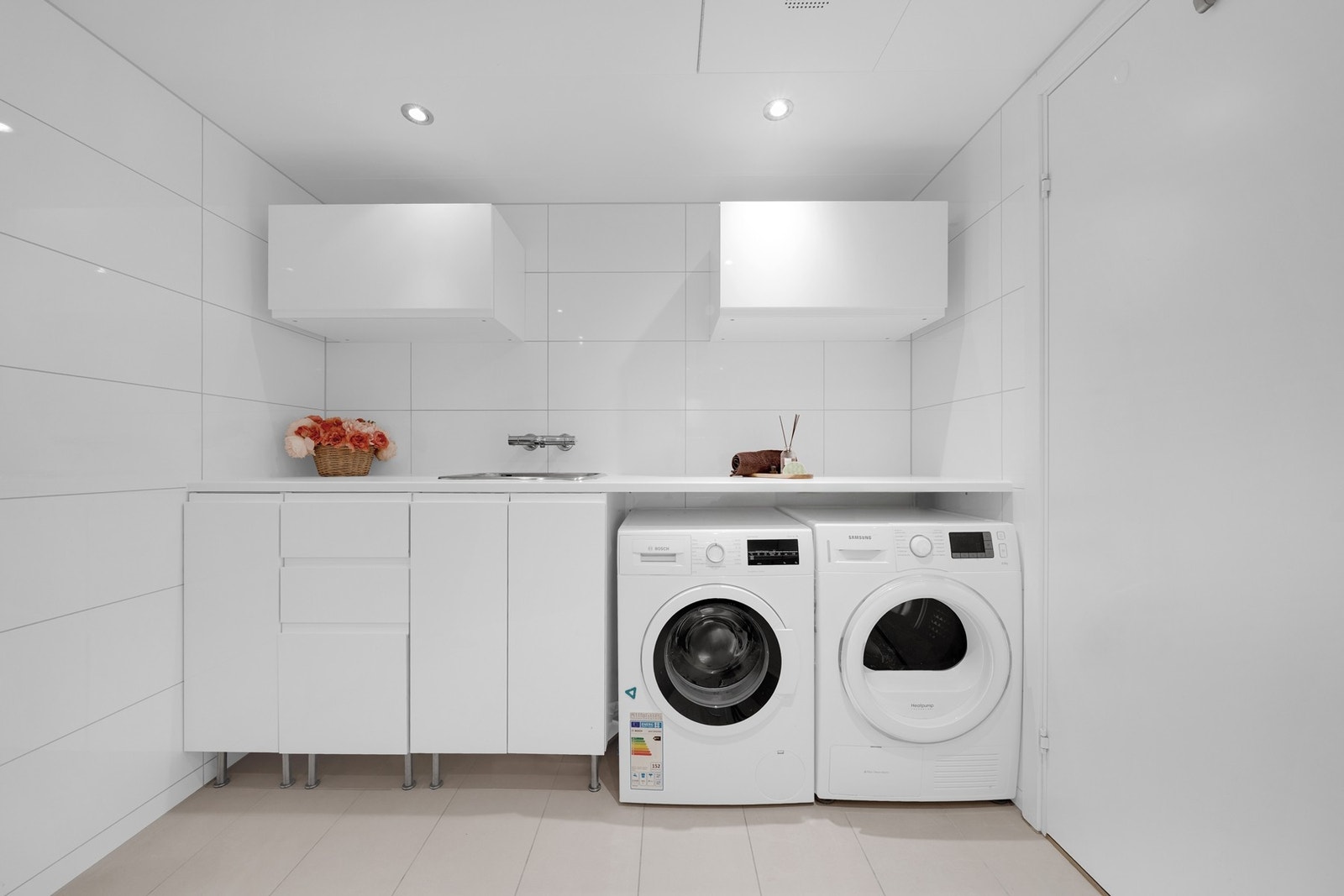Praktisk benkeinnredning med nedfelt kum og to-greps blandebatteri, samt plass og opplegg for vaskemaskin og tørketrommel. Galleribilde