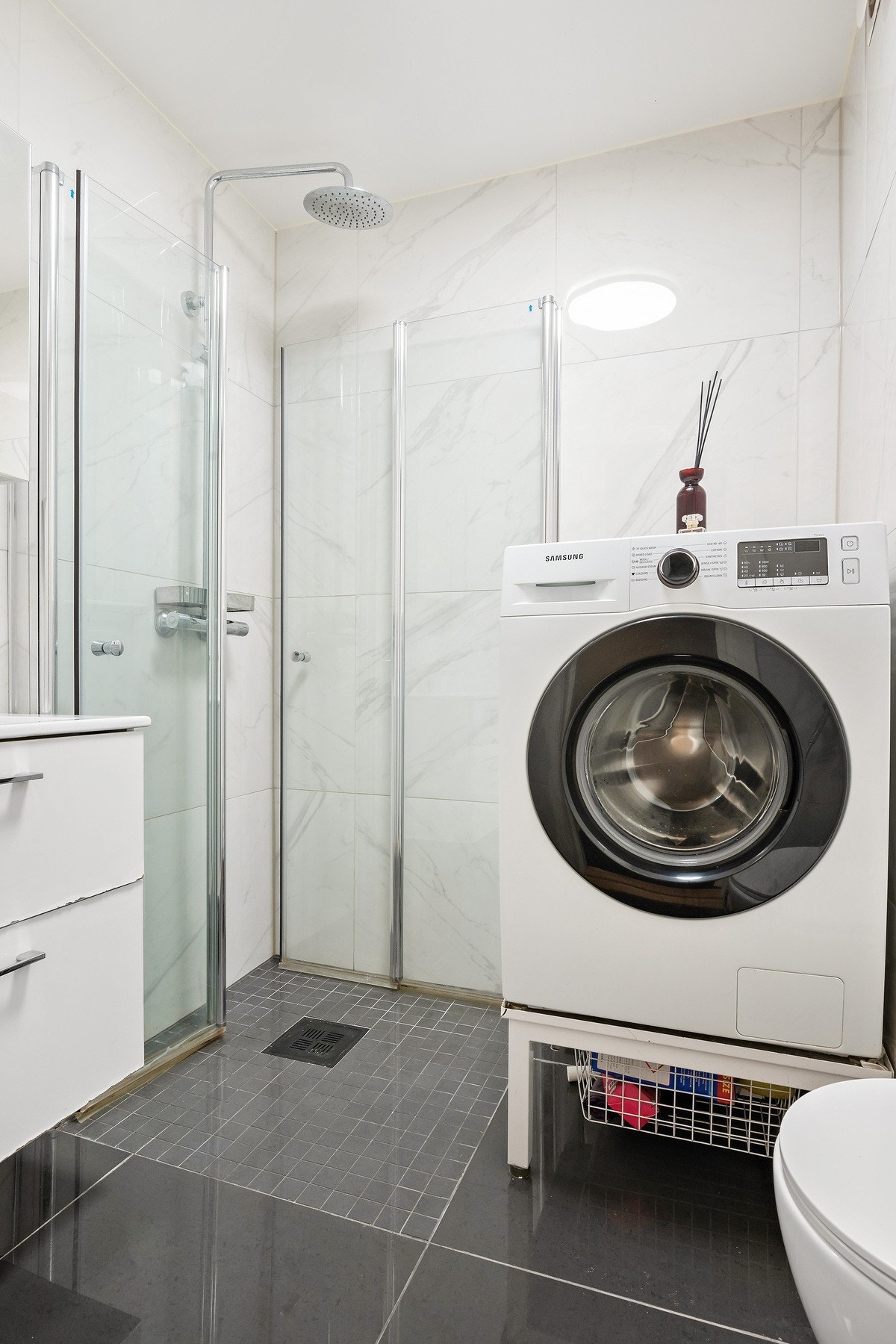 Vegghengt toalett, nedsenket servant med speilskap og opplegg for vaskemaskin. Galleribilde