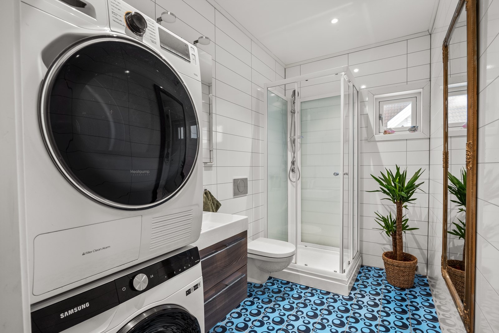 I første etasje er det baderom/vaskerom med vegghengt toalett, dusjkabinett, servant med skuffer samt opplegg for vaskemaskin og tørketrommel. Galleribilde