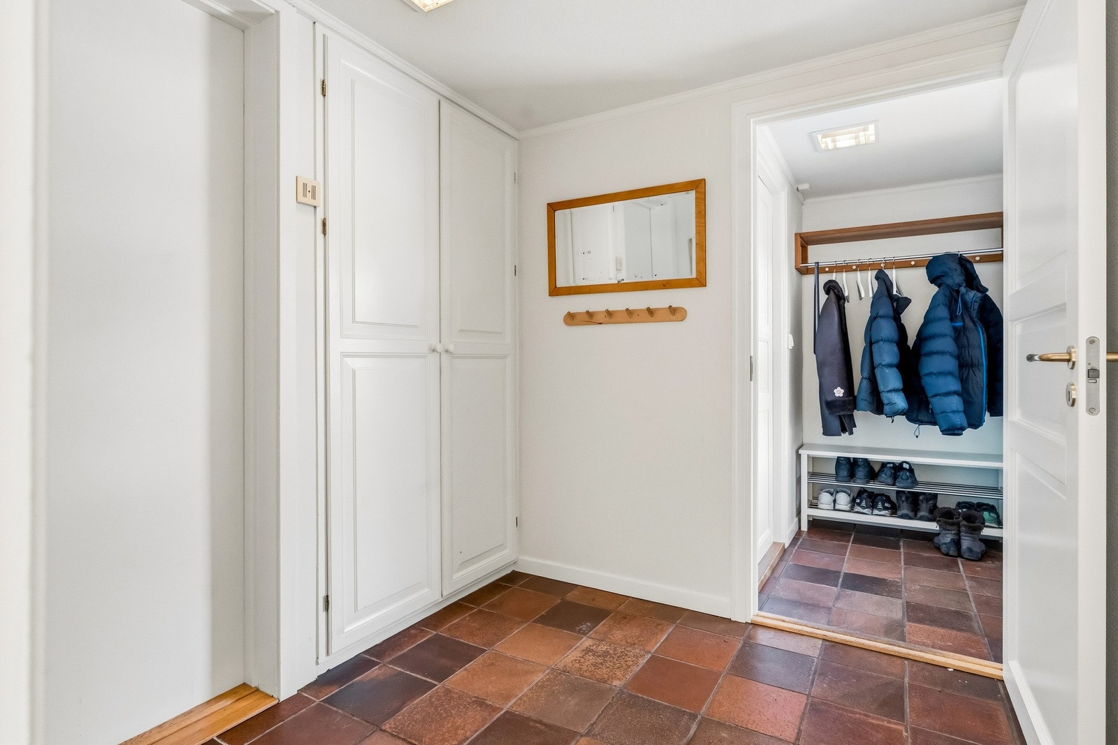 Boligen har egen inngang og både vindfang og mellomgang har flislagt gulv med varmekabler. Her er det innfelte garderobeskap og hylleplass. Galleribilde