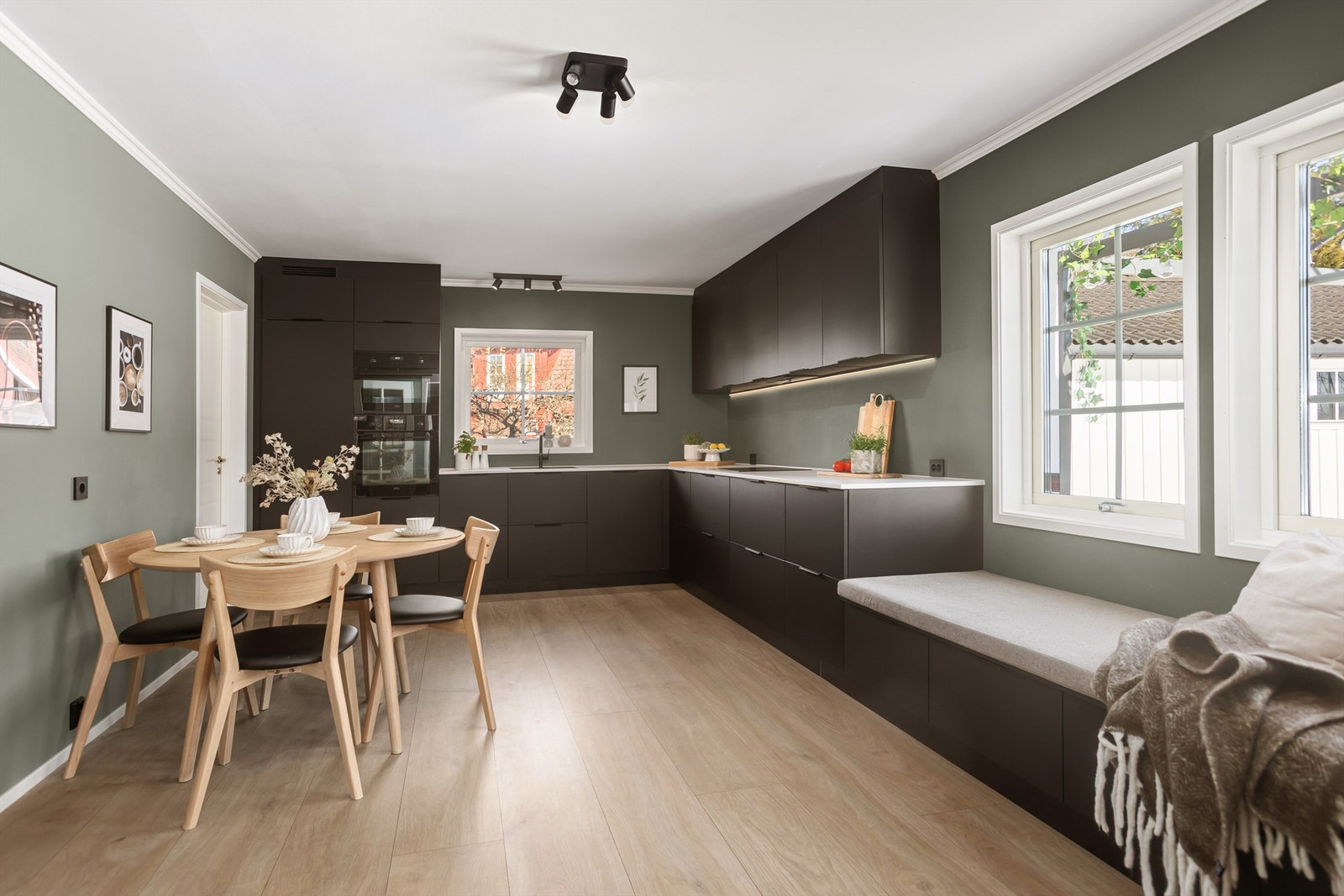 Pent kjøkken med integrerte hvitevarer og god plass til spisebord Galleribilde