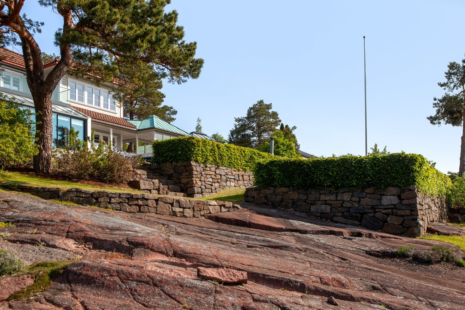 Deler av eiendommen er naturtomt med fjell i dagen, synlig Tønsbergitt og stedlig vegetasjon. Galleribilde