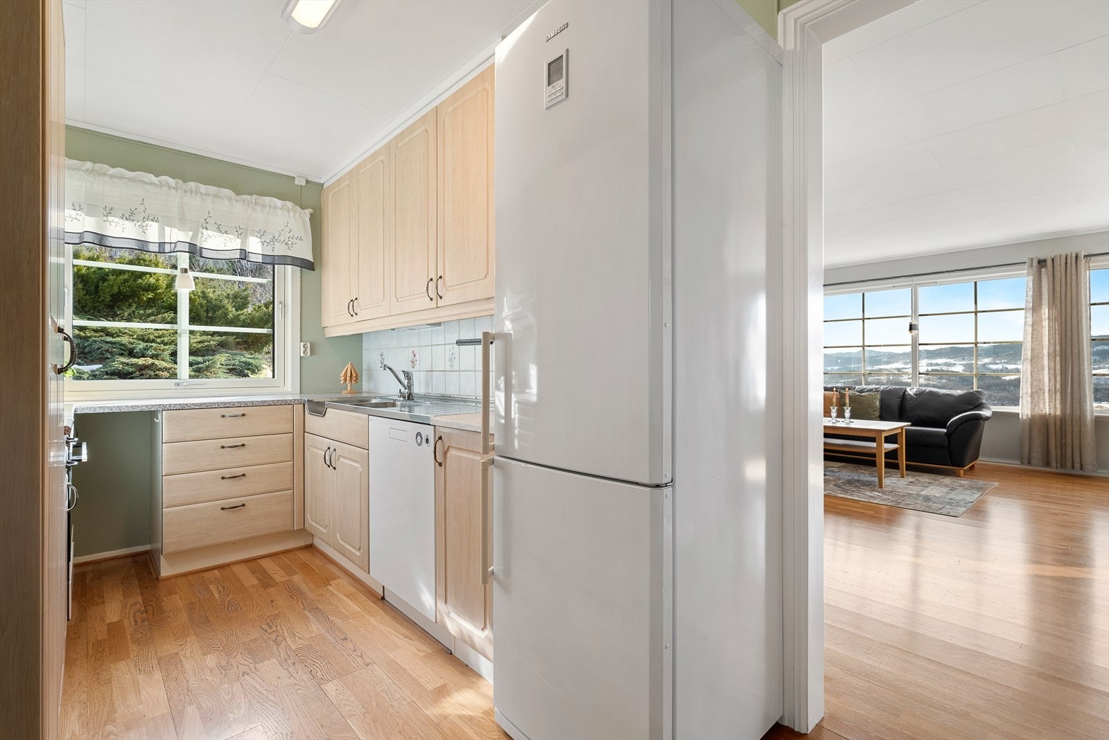 Kjøkkenet ligger innenfor stuen, og det er fin kontakt mellom sonene. Galleribilde