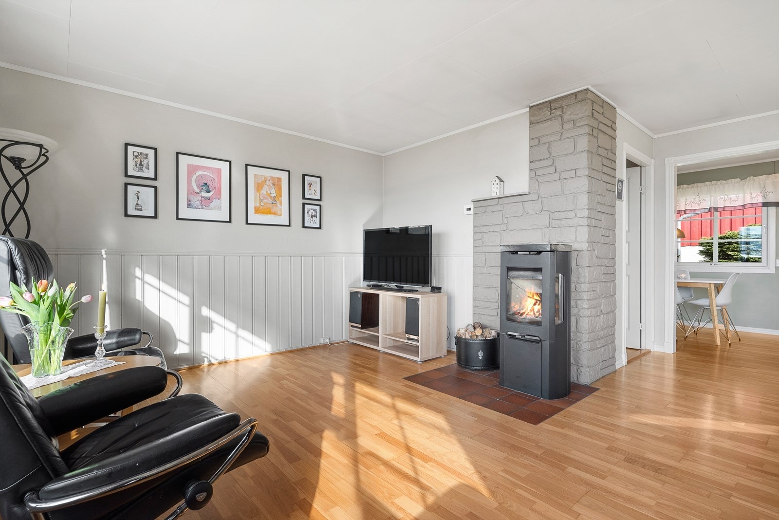 Lite slår avslappende kvelder foran en peisovn med glassfelter. Galleribilde